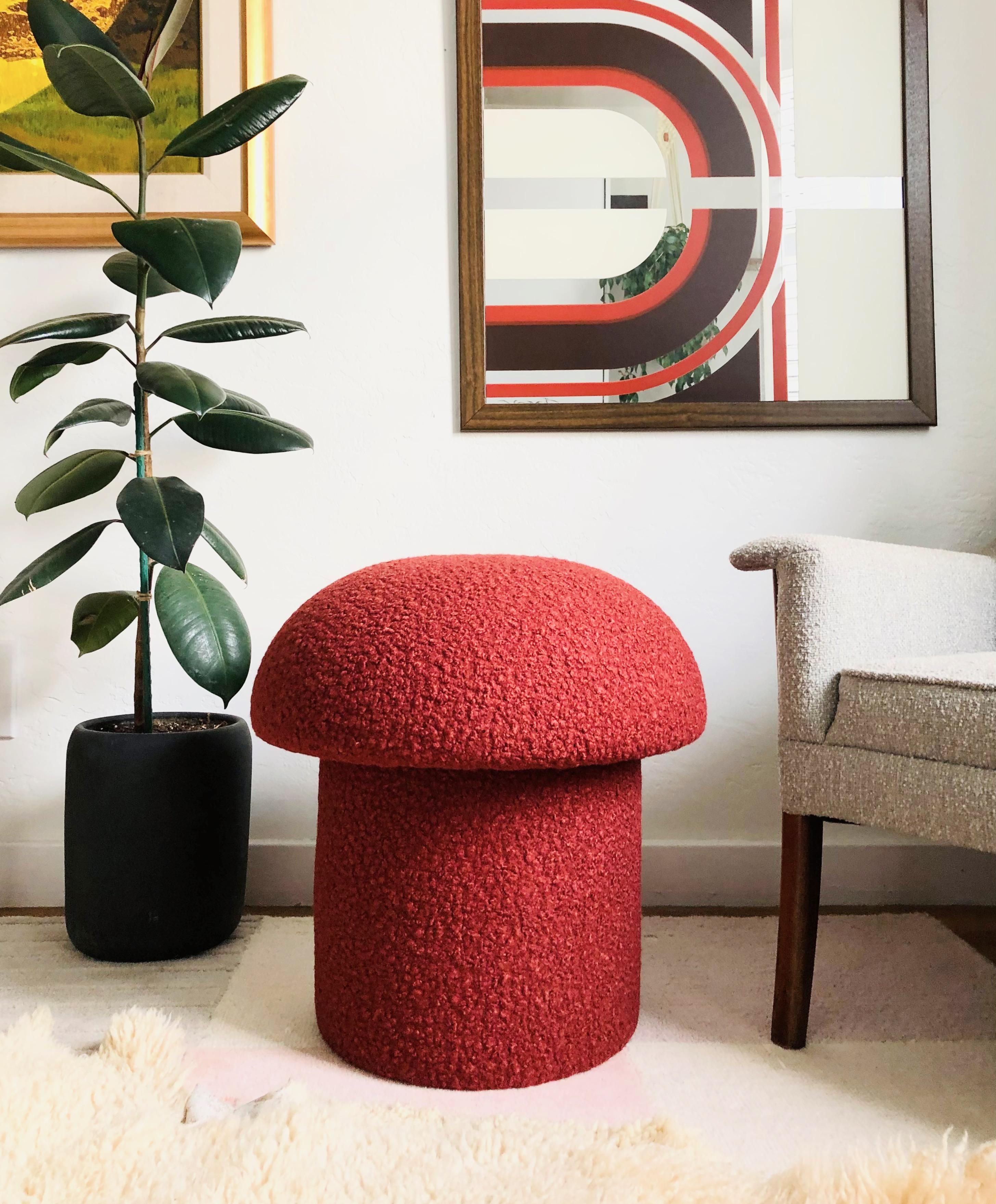 A handmade mushroom shaped ottoman, upholstered in a rust colored curly boucle fabric. Perfect for using as a footstool or extra occasional seating. A comfortable cushioned seat and sculptural accent piece.
     