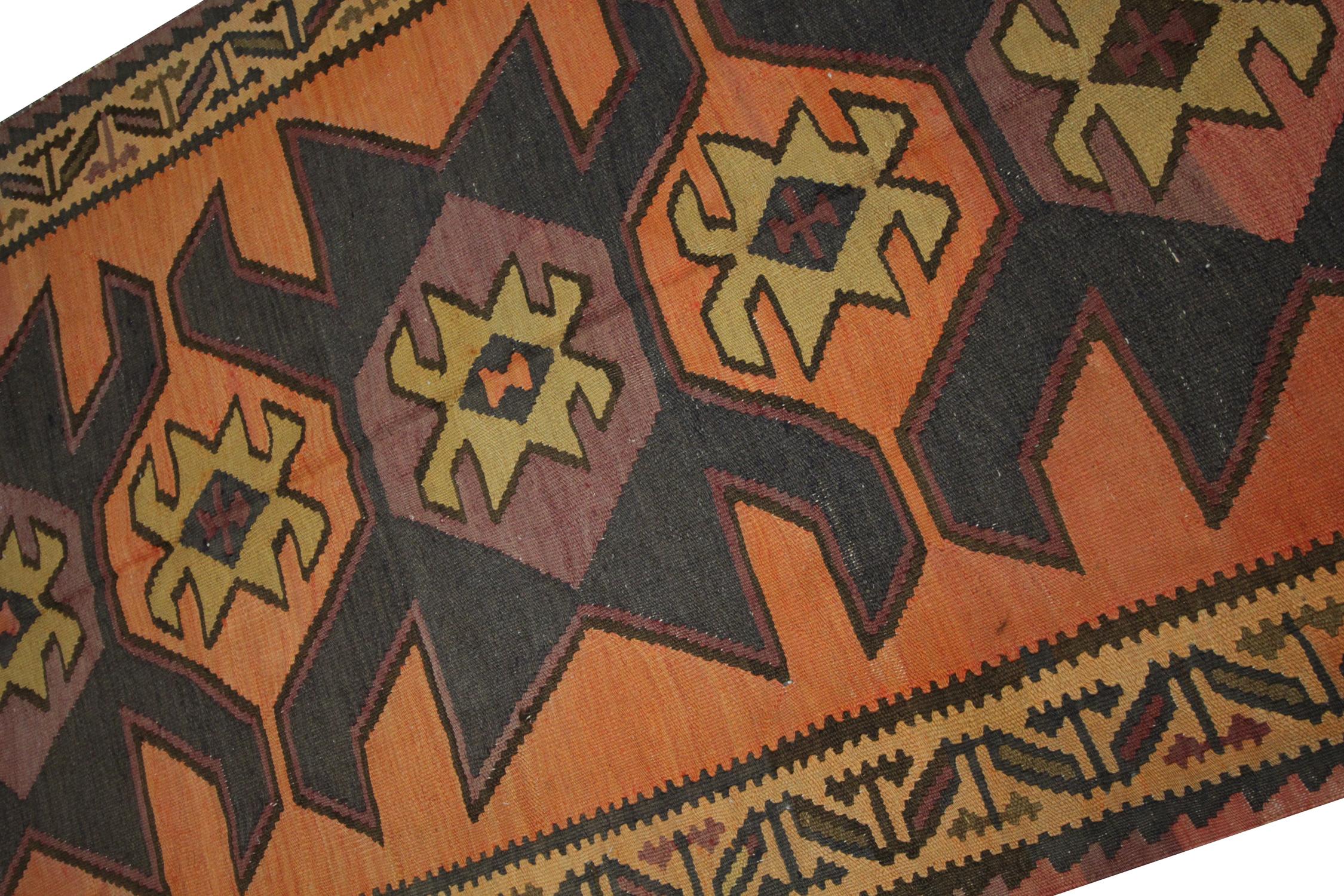 Setzen Sie ein gewagtes Design-Statement mit diesem Vintage-Kilim-Läufer, einem handgefertigten geometrischen Stammesteppich aus Wolle der 1940er Jahre in satten Rost-, Braun-, Senf- und Goldtönen. Dieser in traditioneller Kelimtechnik flach gewebte
