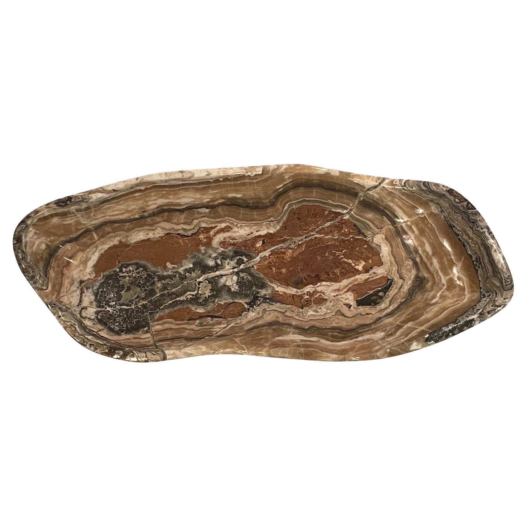 Contemporary Moroccan free form shaped onyx bowl.
Rust, grey and beige horizontal striped pattern.
Polished and smooth finish.
Rectangular shape.
Part of a large collection.