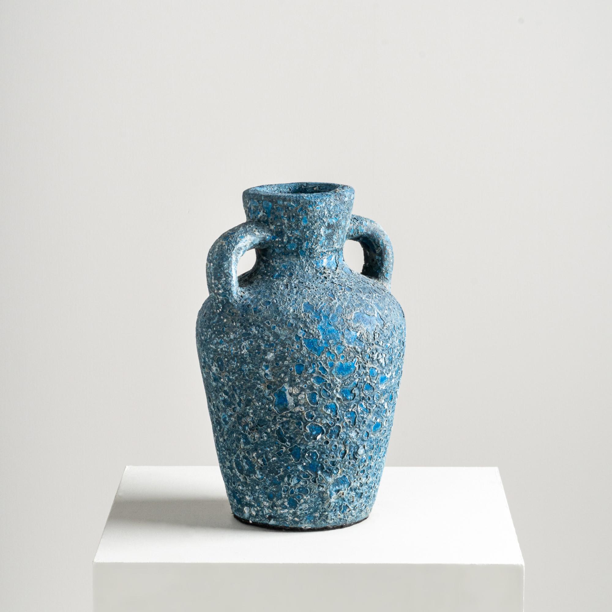 The Rust Vase, in a classic two handle form, discreetly elevates vignettes with textured details. Handcrafted from terracotta clay and adorned with an electric yet rustic finish, infusing a playful yet elegant essence into its overall