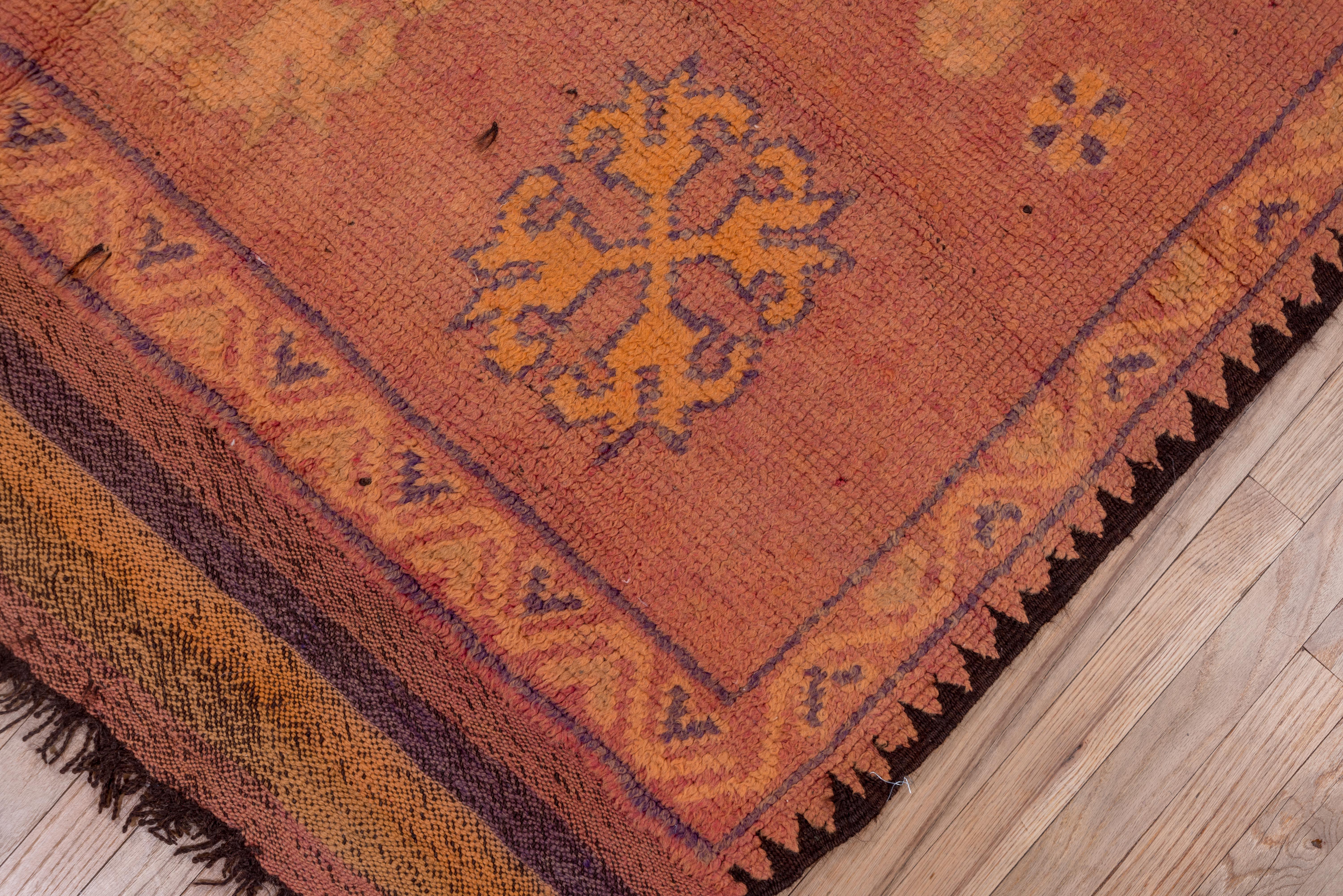 Shades of yellow, brown, orange, red and black make up the border of this exquisite village rug (Morocco) and the center field is filled with hand-knotted designs passed down through generations.