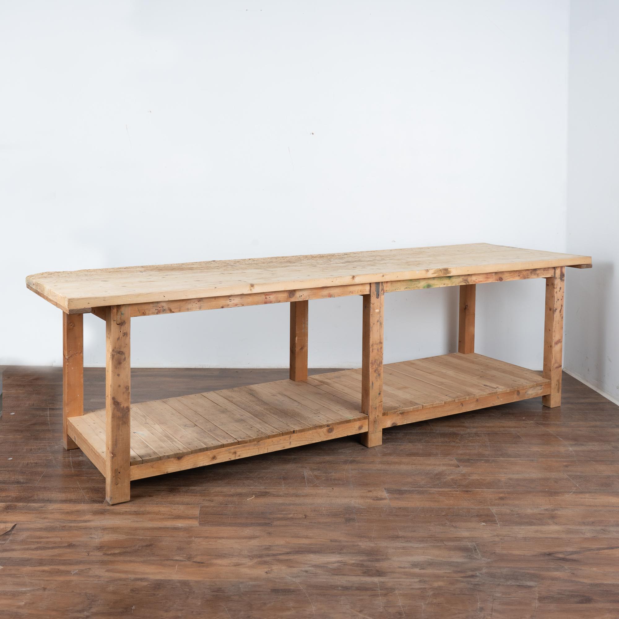 This rustic work table is over 10' long with lower shelf and six legs.
This heavily used table reflects generations of use in every gouge, nick, scratch, hole, dried worm hole, stain and crack. Residual green paint is also seen in this rugged table.