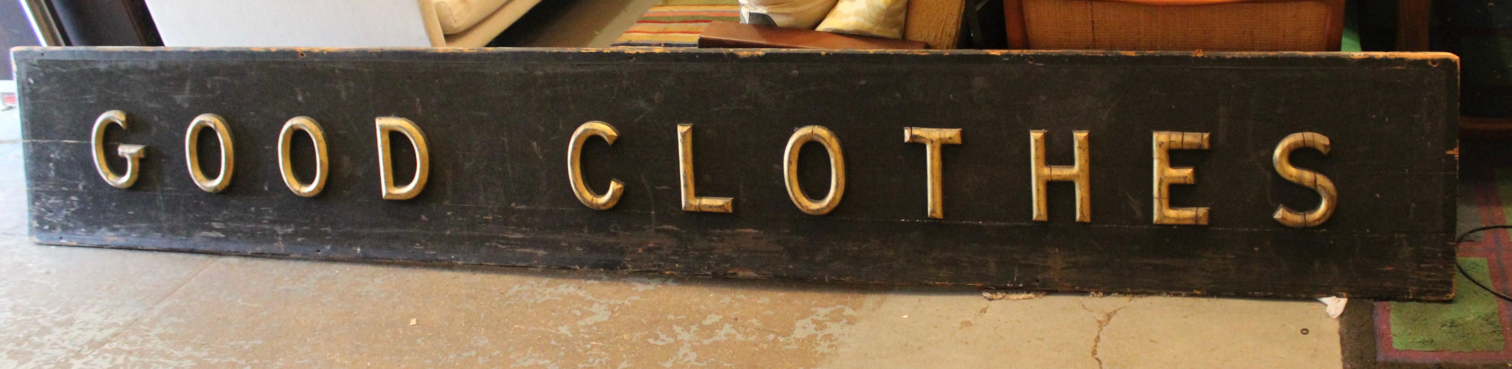 Questa antica insegna di un negozio di abbigliamento è composta da scritte in legno dipinto d'oro su un retro in legno dipinto di nero. L'enorme lunghezza di 12 piedi e le scritte in oro su nero sono un pezzo pubblicitario eccezionale.
Si prega di