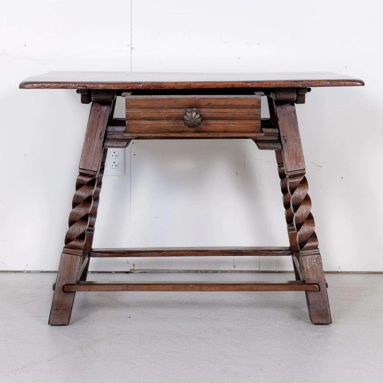 Rustic 18th century Spanish Baroque period side table handcrafted in the early 1700s of solid walnut in the Catalan region having a rectangular top decorated with fruitwood inlay forming the word ANNO and the date 1717, as well as the initials FMCC