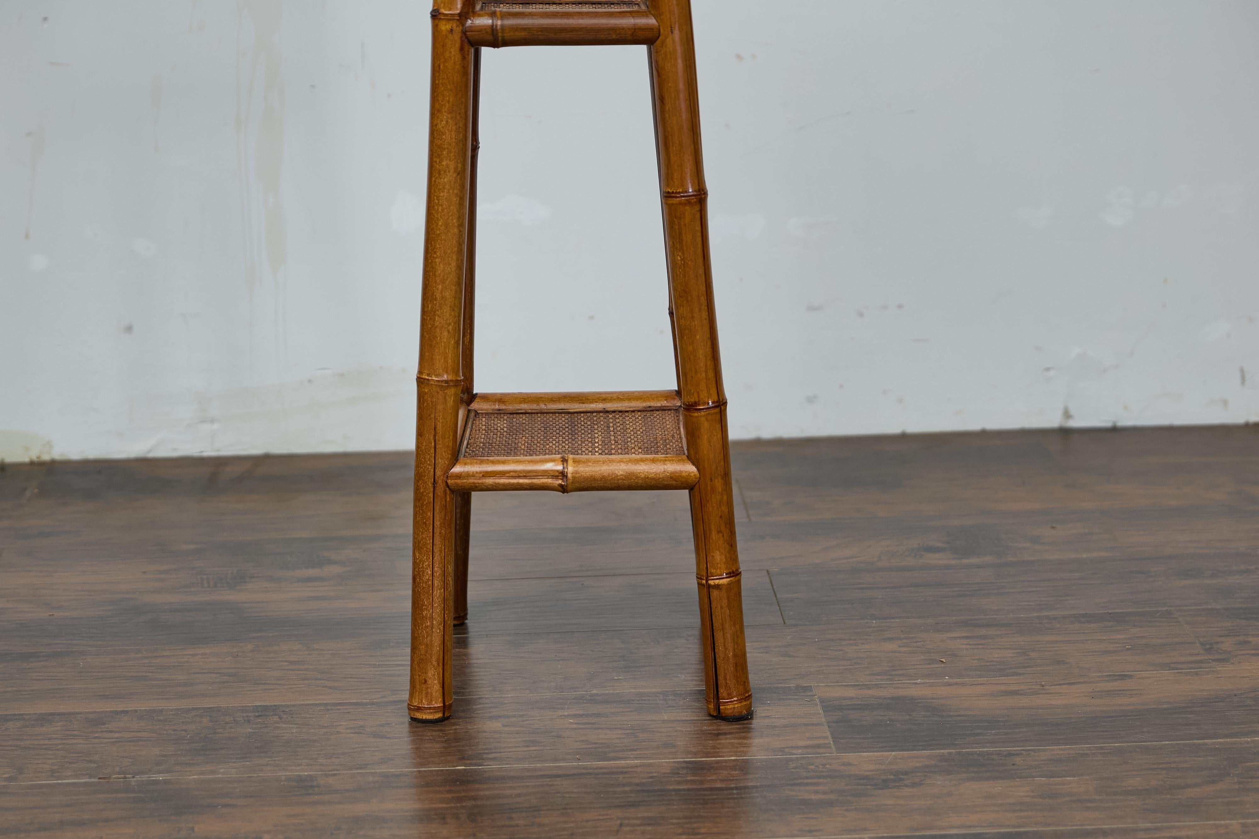 This antique rustic English walnut faux bamboo stand, dating to the 1920s, showcases both timeless charm and exceptional functionality. Its tall, slender frame features elegant faux bamboo detailing, exuding sophistication and versatility. Designed