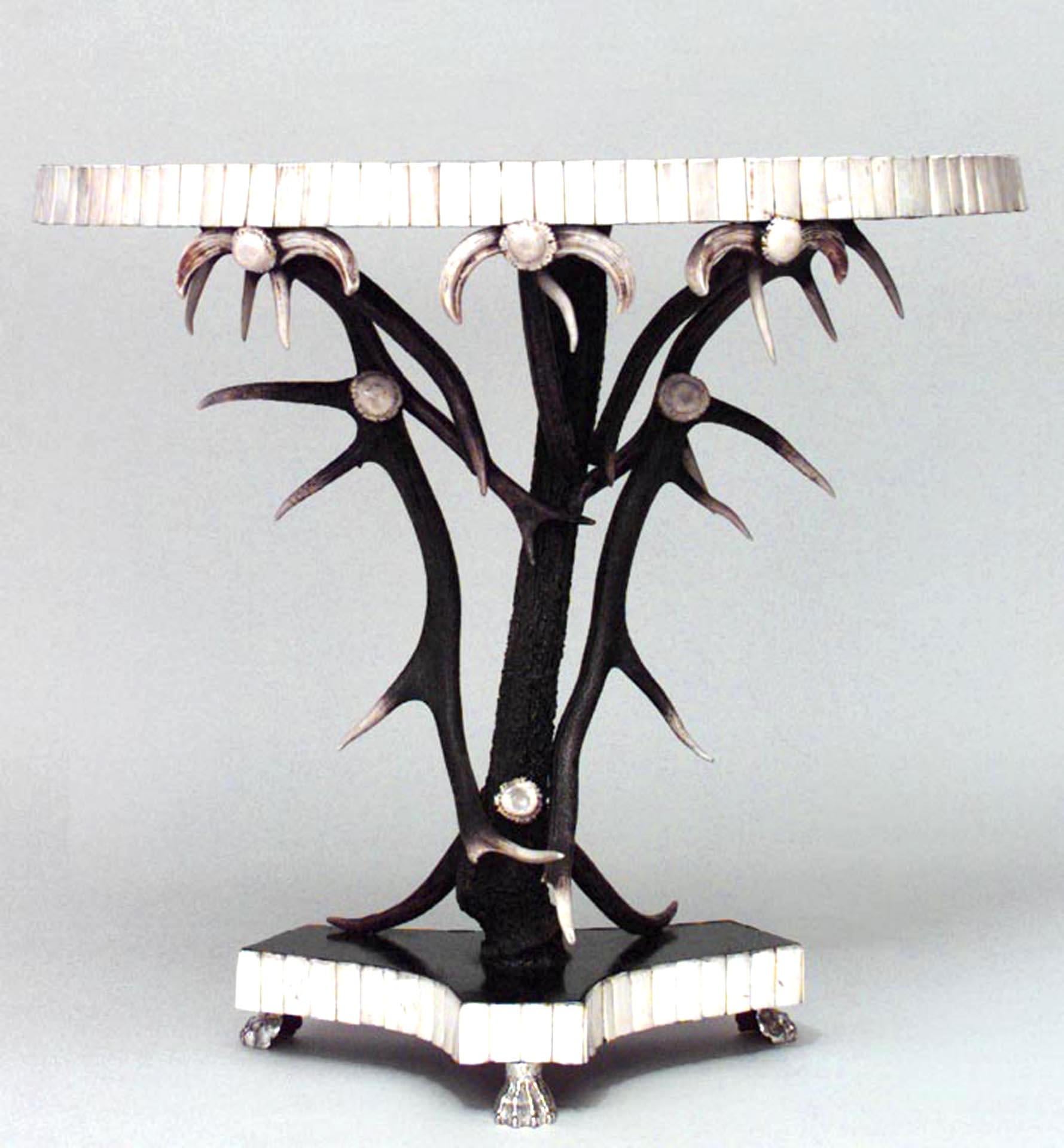 Consolle rustica continentale (XX secolo) con design in corno ed ebanizzato, con finiture in osso e base triangolare con 3 piedi ad artiglio argentati.
