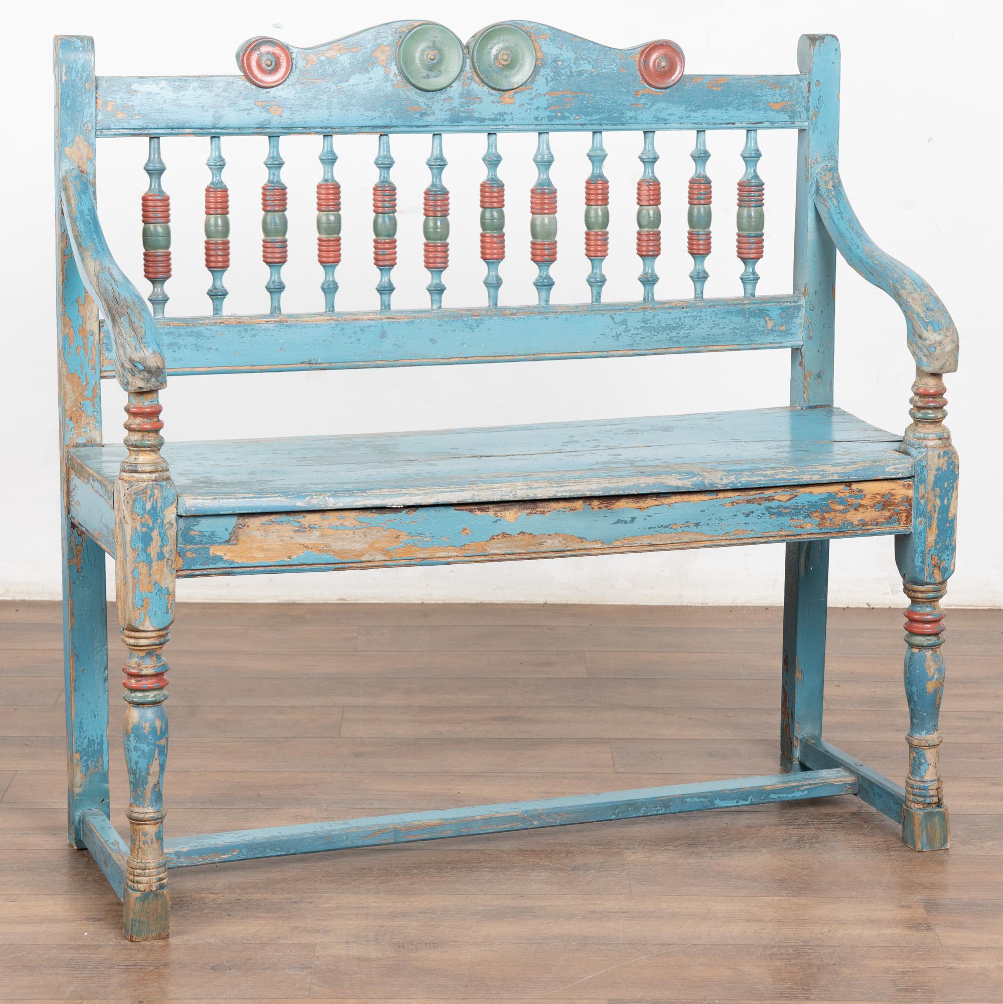Fun and festive original blue painted bench that has been naturally worn and distressed over time revealing the natural pine below, all adding to the character and charm of this delightful 3.5' long bench. Accent colors of red and green decorate the