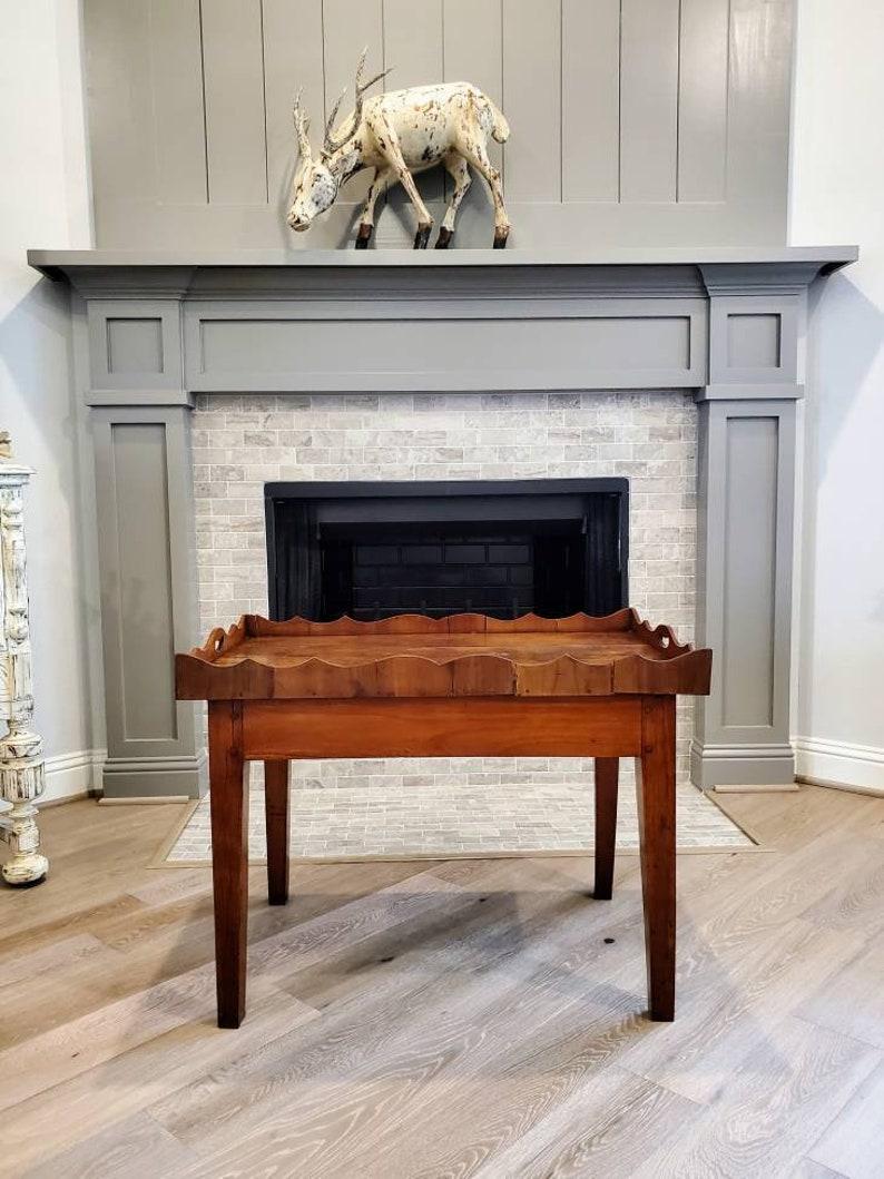 From the home of the legendary businessman, T. Boone Pickens, we are proud to present a rustic Provincial cherry wood tray top table with beautiful patina. 

Constructed in the late 19th century from earlier elements, having an old cherry base,