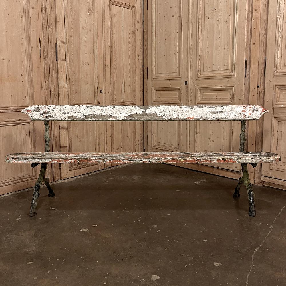 Rustic 19th century French garden bench with cast iron legs was produced for a private garden, and the leg castings were designed to mimic the gnarly branches of the surrounding trees. Two old oak planks serve as the seat and seatback, and the