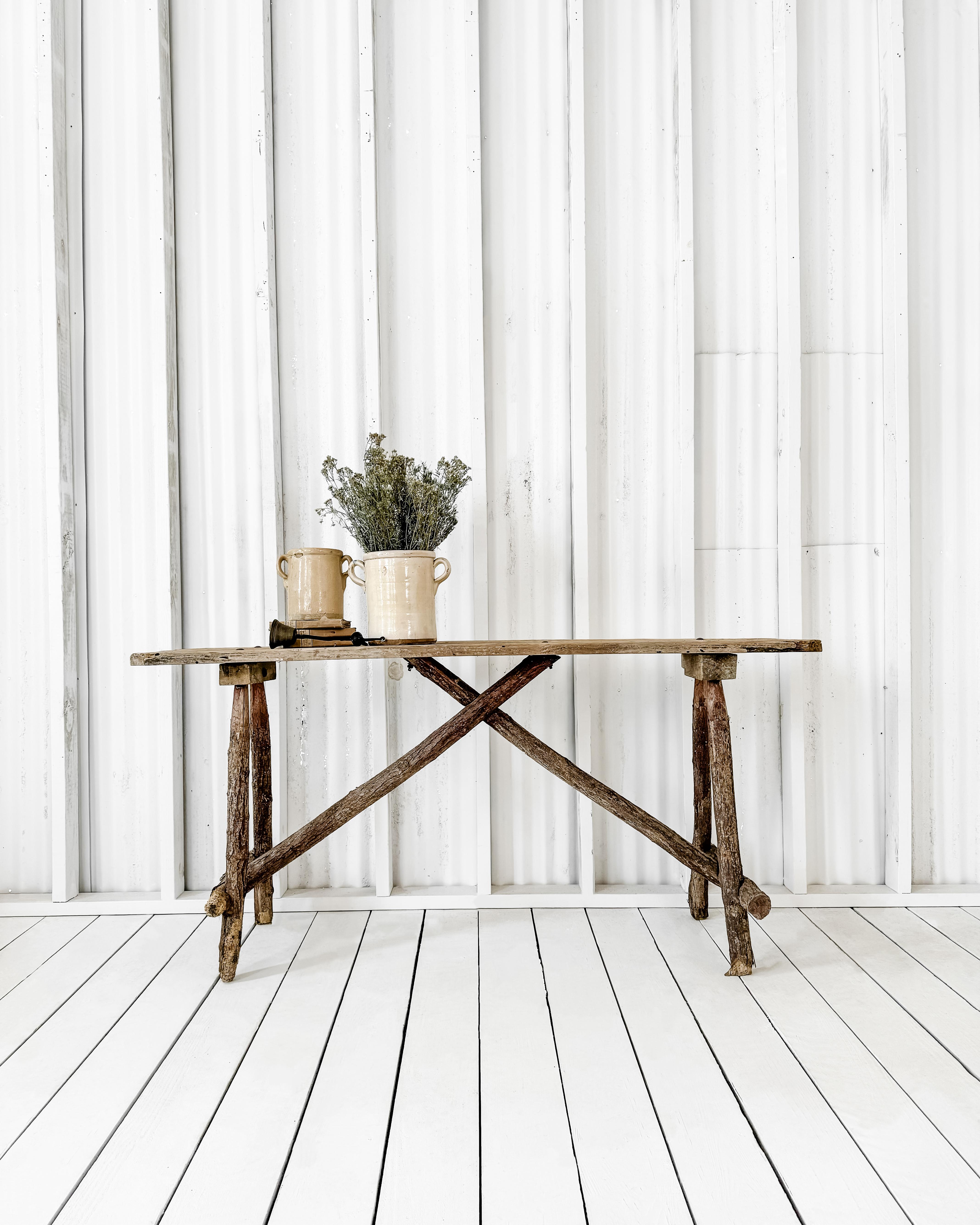 Rustic French laundry table featuring a single board top. A popular tool used for washing clothes in the French countryside, the handcrafted table boasts A-frame legs constructed from tree branches. Worn and weathered with a beautiful patina, the