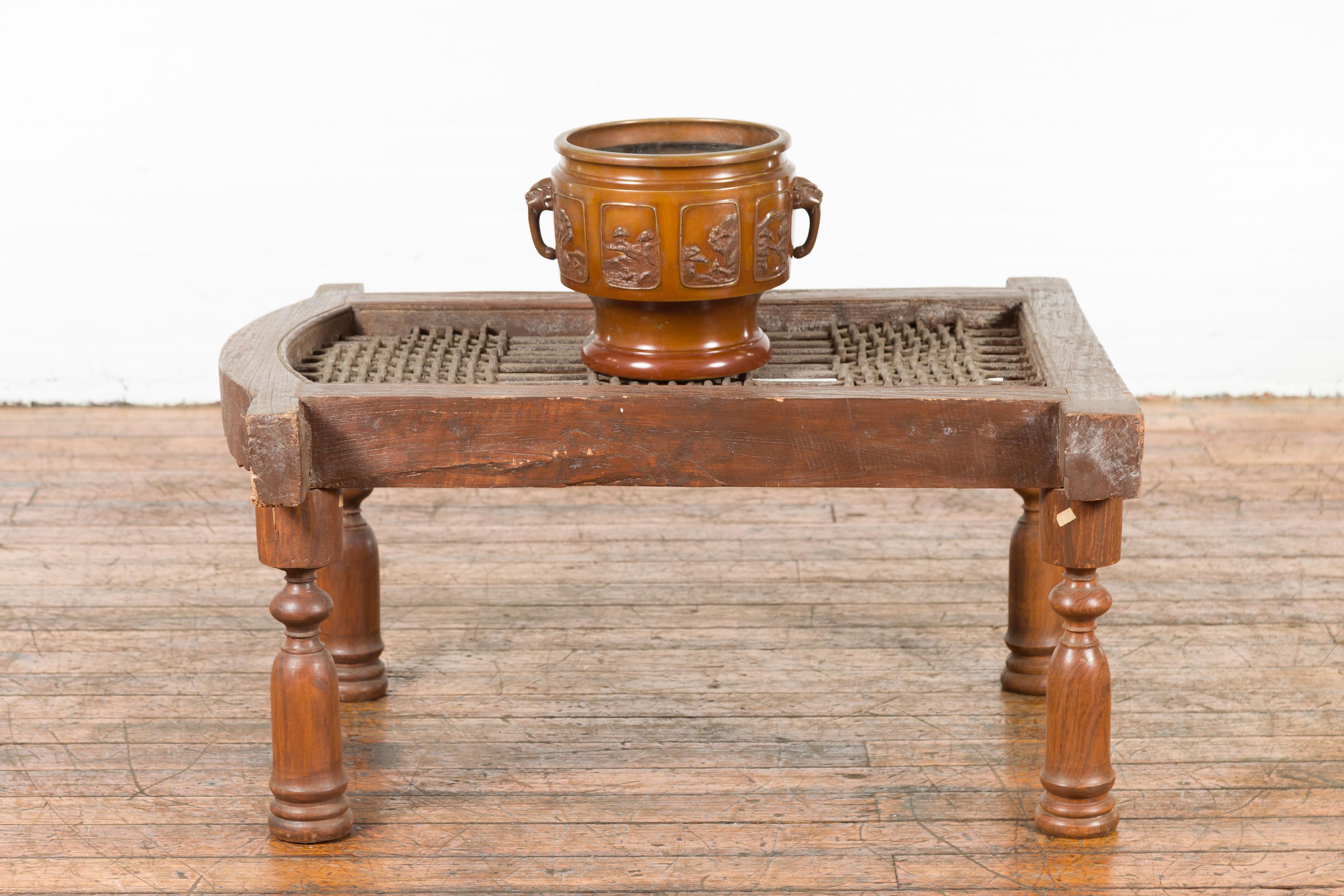 An antique rustic Indian window grate from the 19th century, made into a coffee table with baluster legs and weathered appearance. We have more assorted sizes available, please contact us with any questions. Introduce a piece of Indian architectural