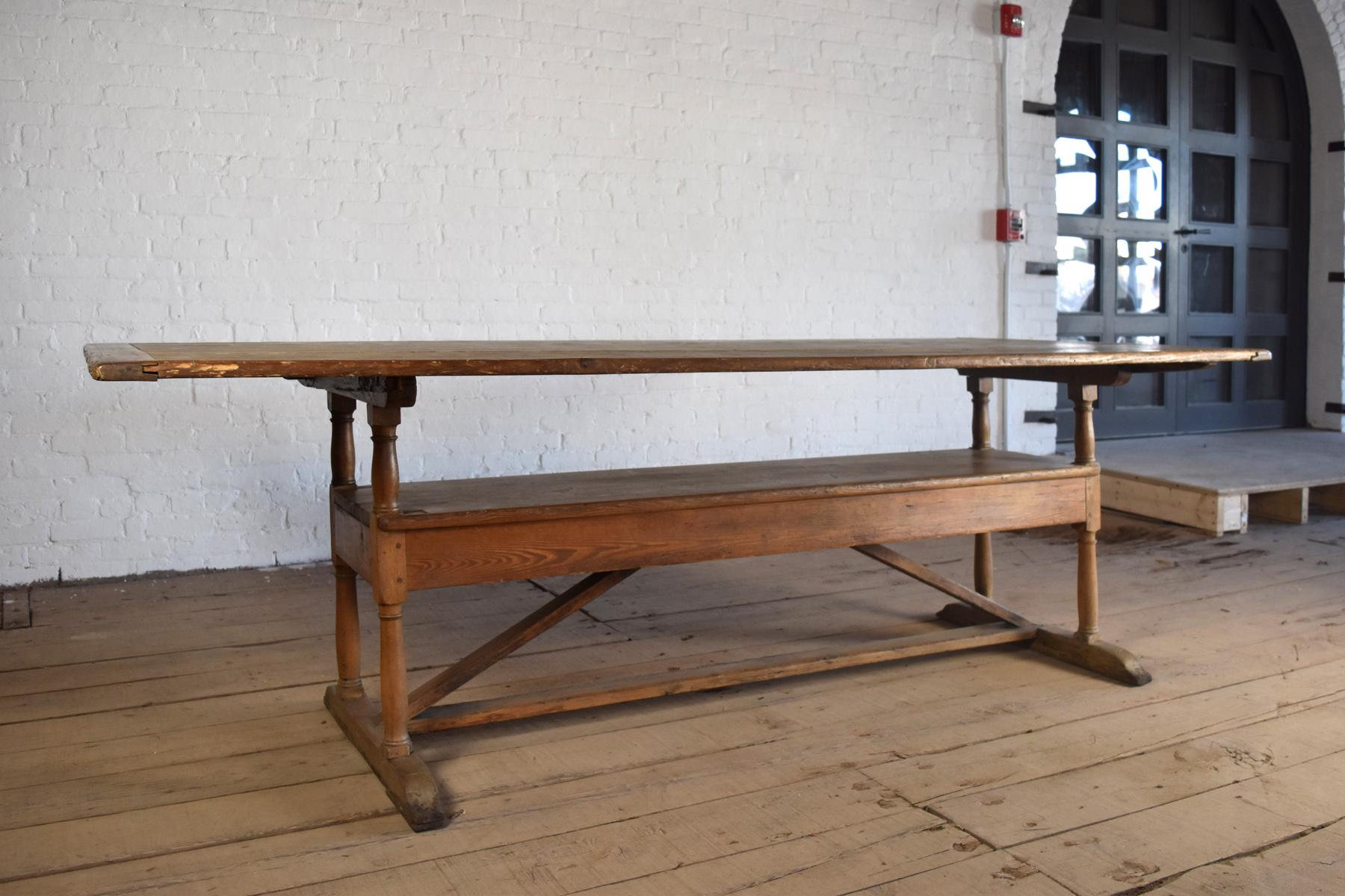 

Unique and of charming asymmetrical design, with one end of the table having a bigger overhang, (Likely the seat of the Head of the family)
The table top can rotate back on two pins holding it and transform into a bench.
With this double function