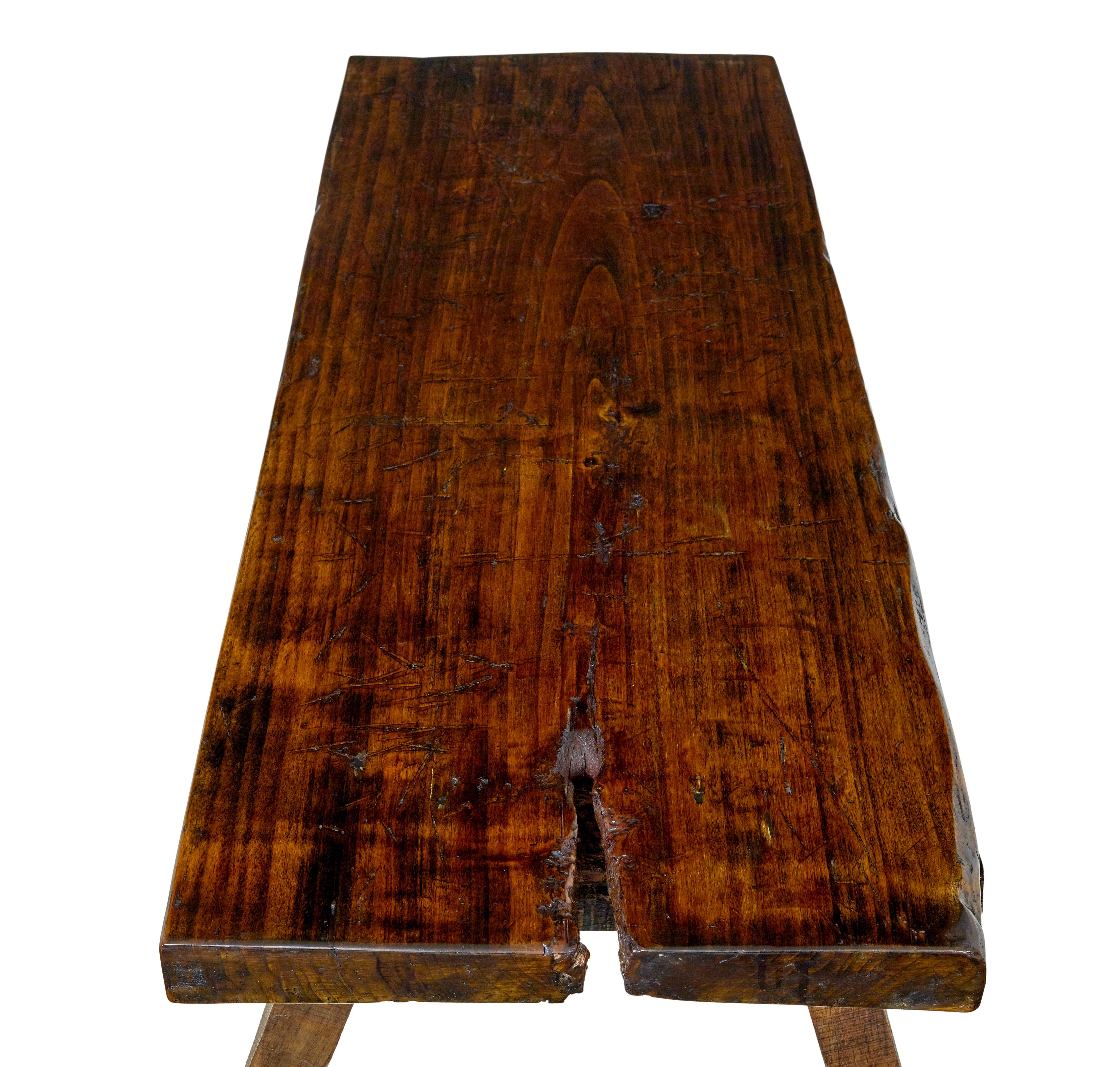 Rustic 19th century elm bench circa 1860.

Known as a pig bench, this bench made from 1 solid piece of elm offers and excellent opportunity to work as a coffee table.

Rectangular top with natural form of the tree left on 1 end.  Standing on 4