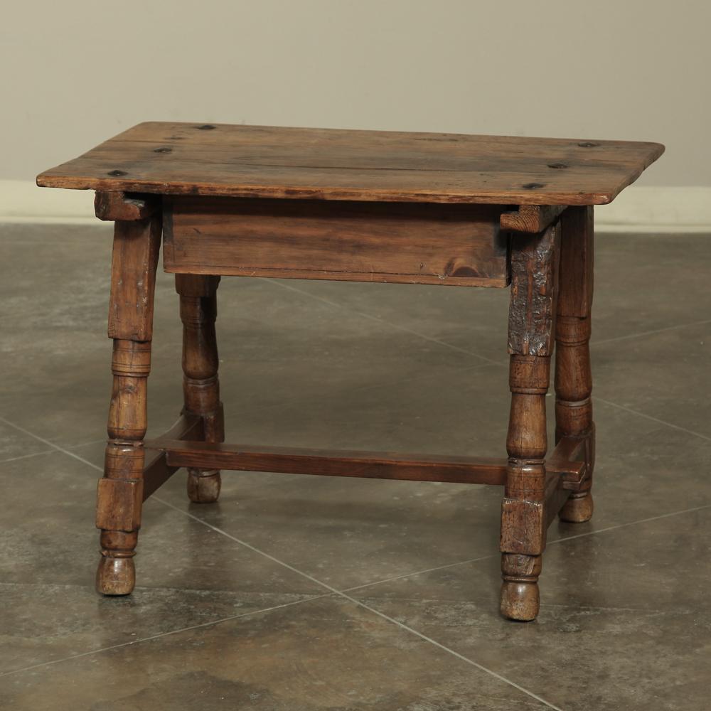 Rustic 19th century Spanish end table was hand-crafted out of solid, old growth oak, and features turned legs flared out for extra stability, and reinforced with a classic 