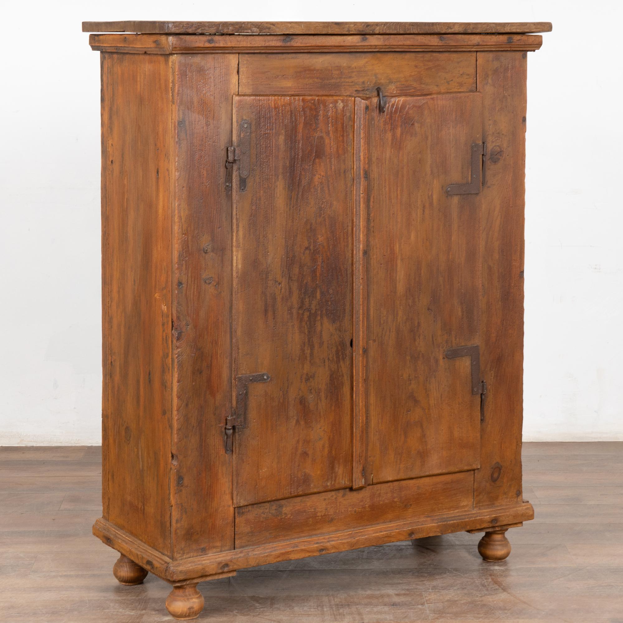 Dieser rustikale Schrank im Landhausstil ist 4' hoch und behält seinen schlichten ländlichen Charme mit alten Scharnieren und einem Riegel an der oberen rechten Tür (kein Schloss).
Die Jahre des Gebrauchs sind in den Kratzern / Furchen entlang der