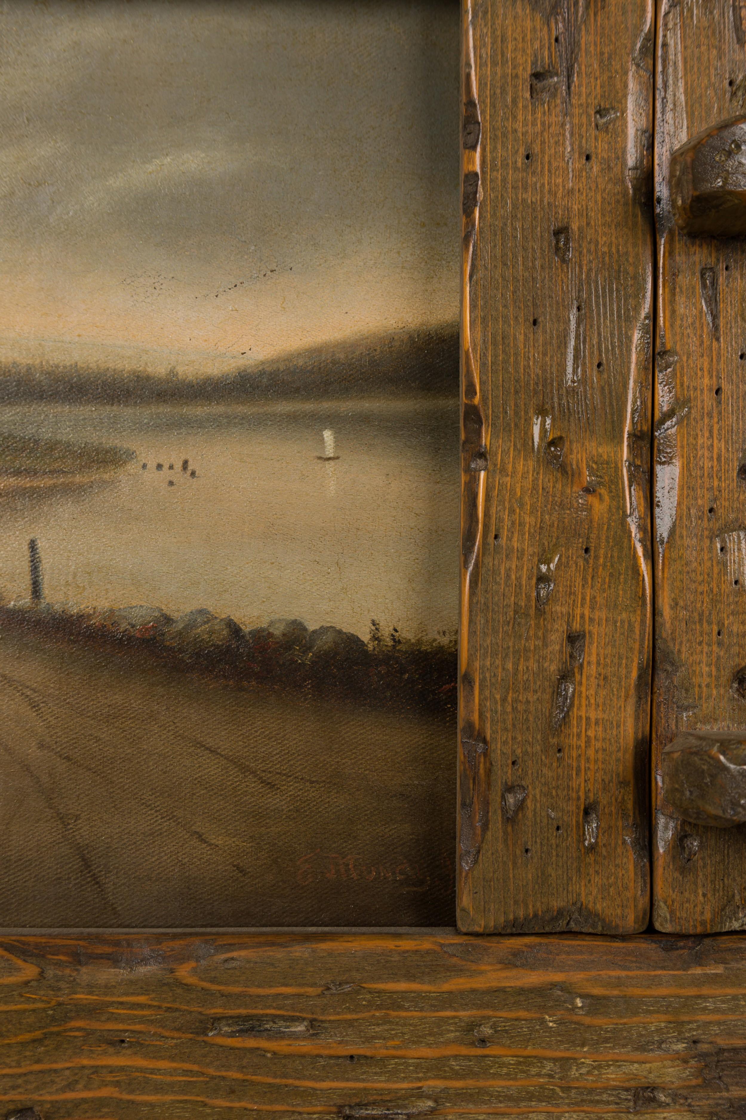 Peinture à l'huile sur toile d'un paysage rustique de style Adirondack représentant une route avec un petit pont près d'un lac, montée dans un grand cadre en bois taillé et usé par les intempéries.

Petit enfoncement avec perte de peinture sur la