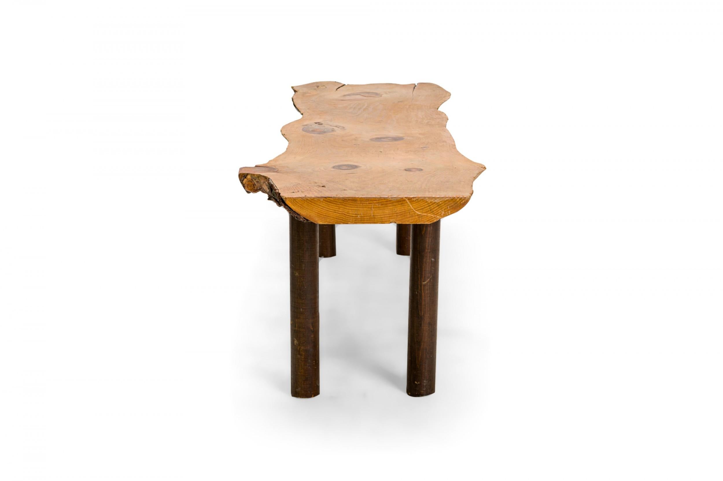 American Country Rustic Adirondack style (20th Century) rectangular free form knotty pine bench with bark trim resting on 4 cylindrical black legs