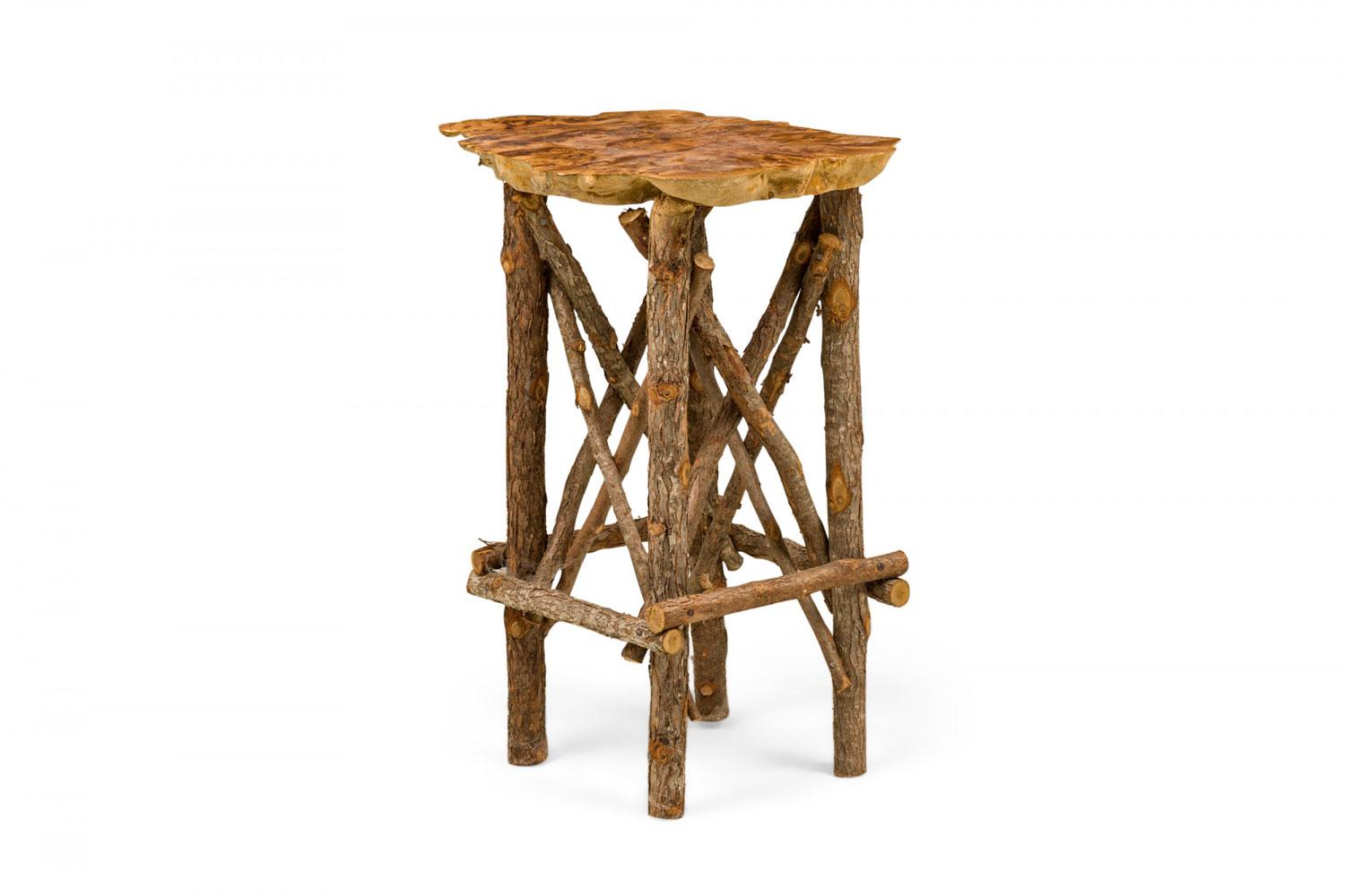 Contemporary Rustic Adirondack end / side table with a petrified wood top with organically scalloped edges supported on a branch base with x-stretchers. (Similar tables: 063374, 063375)