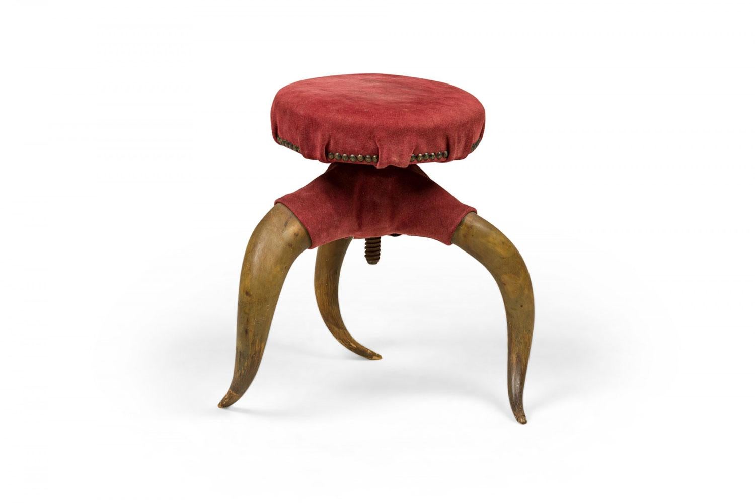 Sgabello rustico vittoriano americano a tre gambe in corno di cervo con rivestimento in pelle scamosciata bordeaux e finiture in ottone sfaccettato.