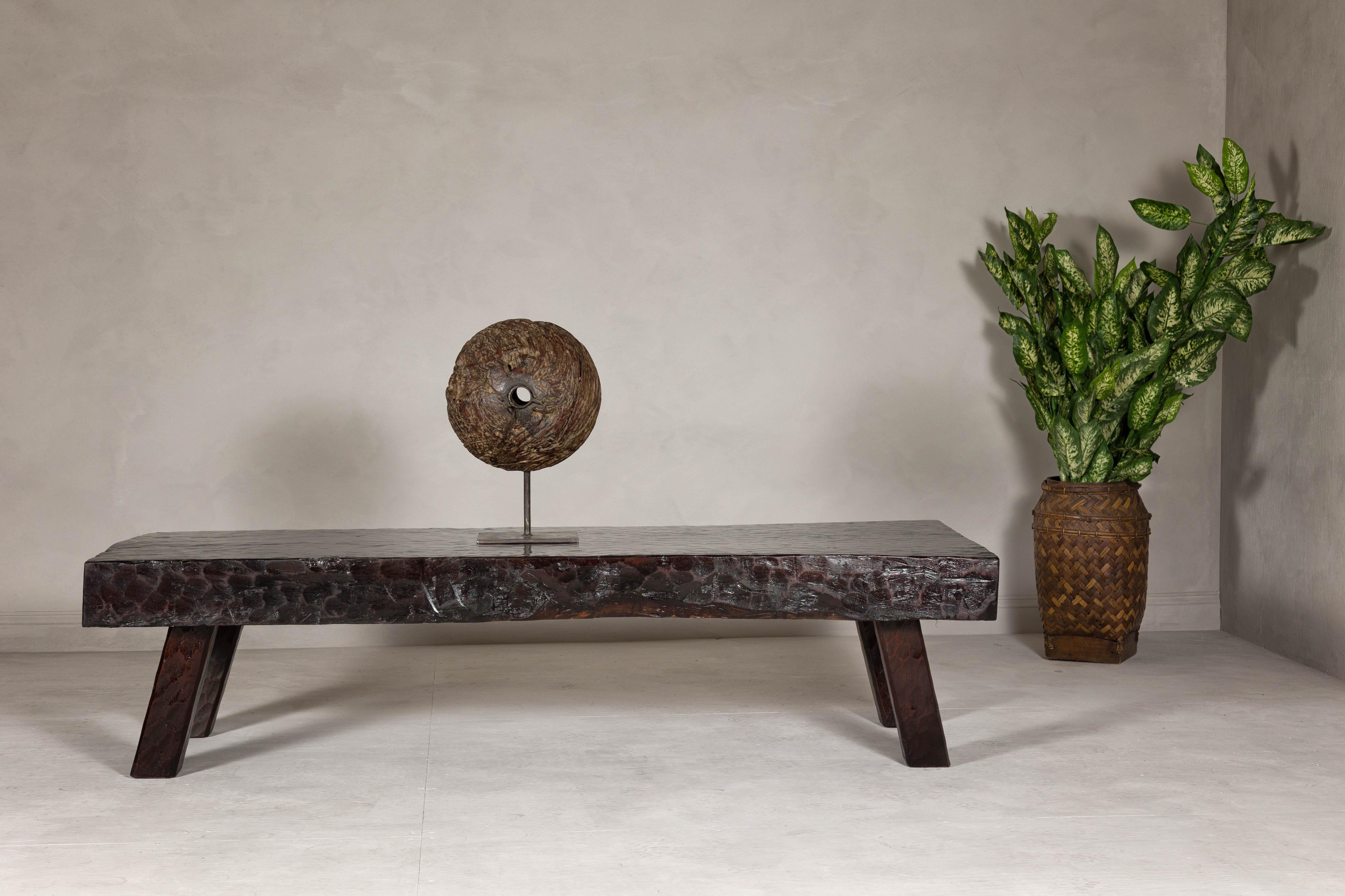 A rustic chunky coffee table with honeycomb patterns and dark patina. This rustic coffee table is a true testament to artisan craftsmanship, featuring a robust and chunky design that immediately draws the eye. Its top is adorned with honeycomb