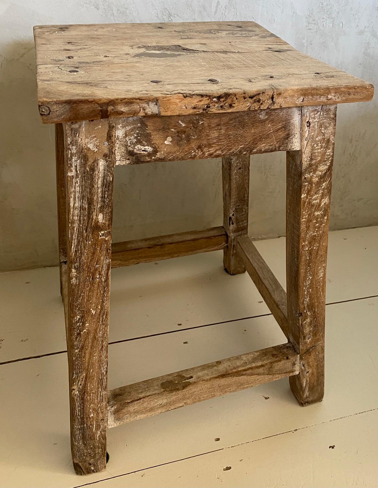 The antique Asian stool has a square top and a balanced form with timeless rustic appeal. Beautifully worn from a century of use, the aged wood patina adds rich texture to the home. It can be used for side table, end table, or extra seating. Great