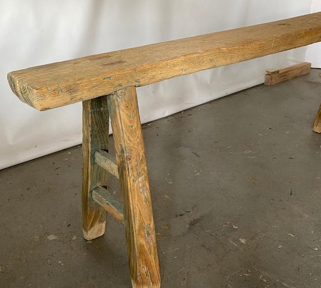 The antique Chinese bench has splayed legs pegged into each seat. The legs are secured with a single stretcher, also pegged. Can be used as dining seating, porch or picnic casual dining. A second similar one available.