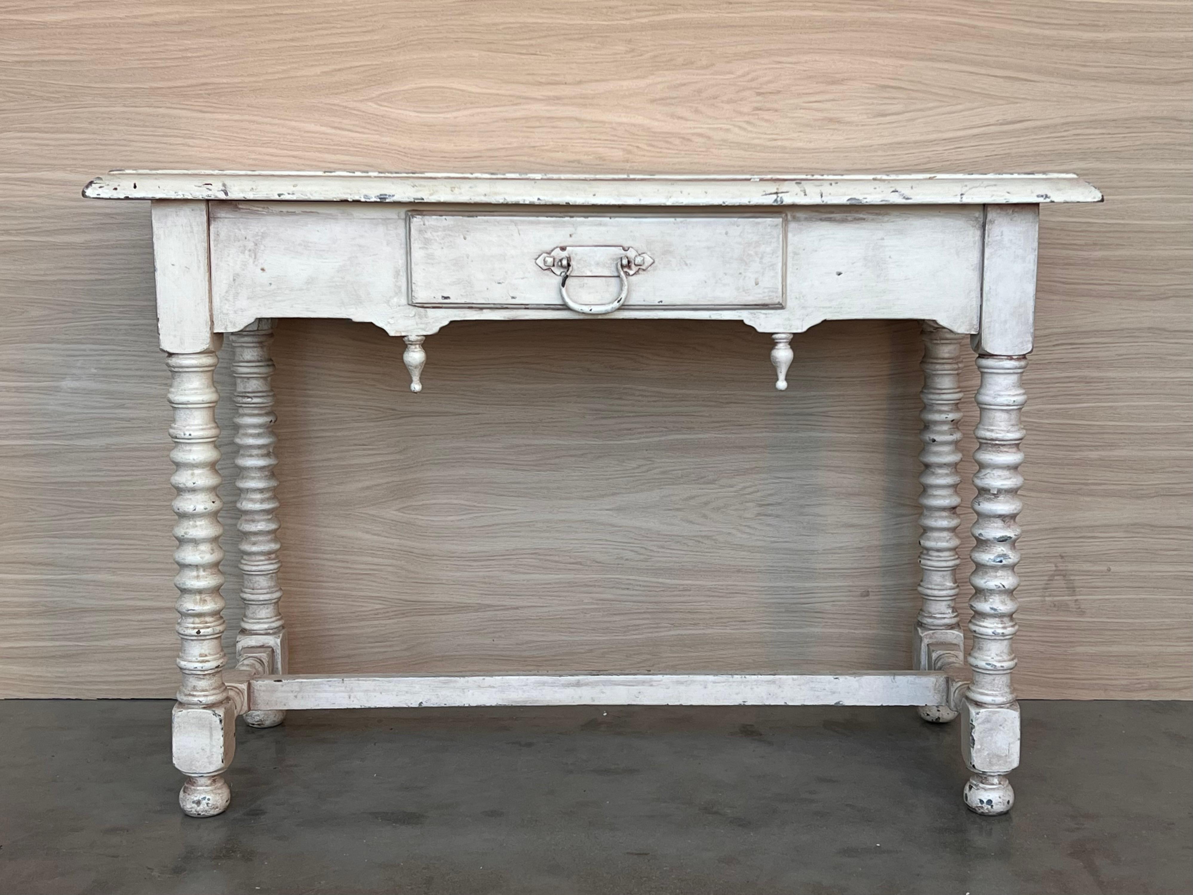 A rustic antique farmhouse harvest table from the turn of the late 19th / early 20th century. Restored, retaining original character, distressed painted white, the plank top with rich, warm antique white color and tone, superb grain pattern and