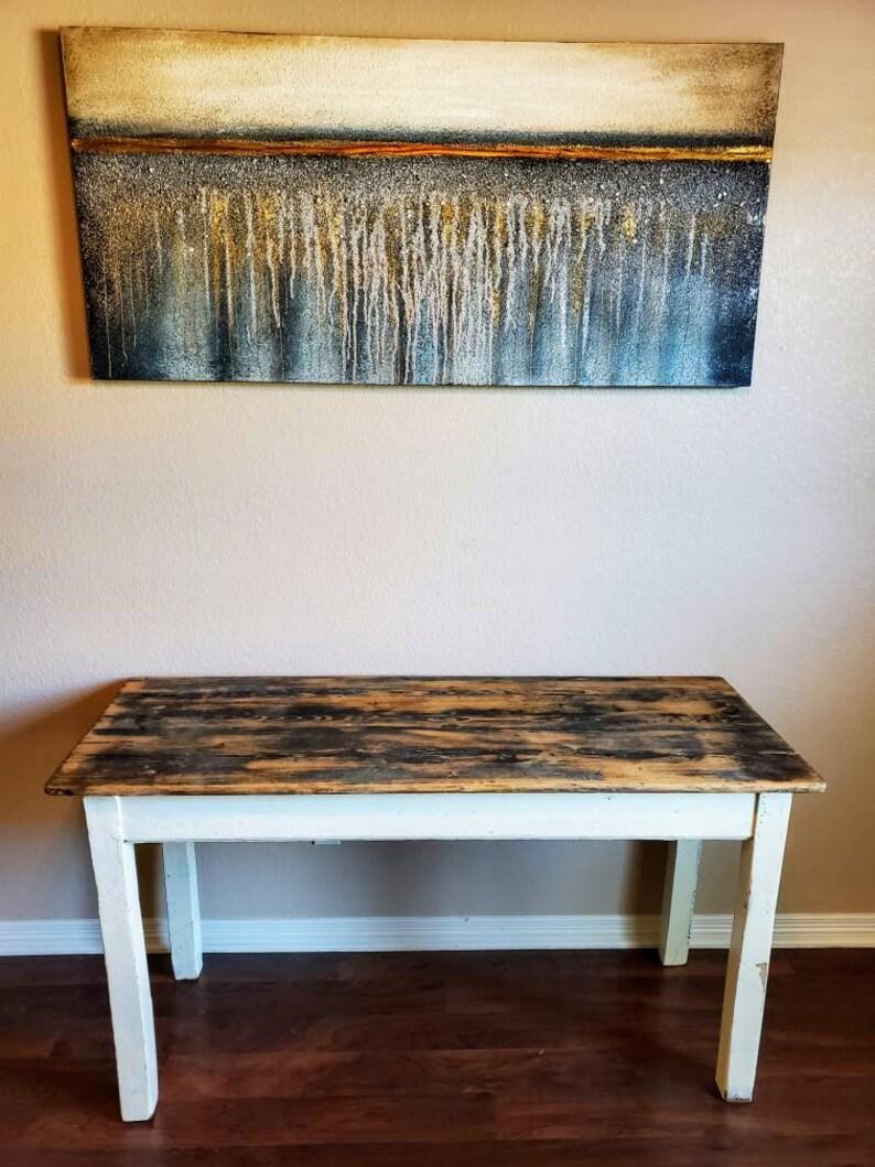 A rustic antique farmhouse harvest table from the turn of the late 19th / early 20th century. Restored, retaining original character, distressed painted white, the plank top with rich, warm antique wood color and tone, superb grain pattern and soft,