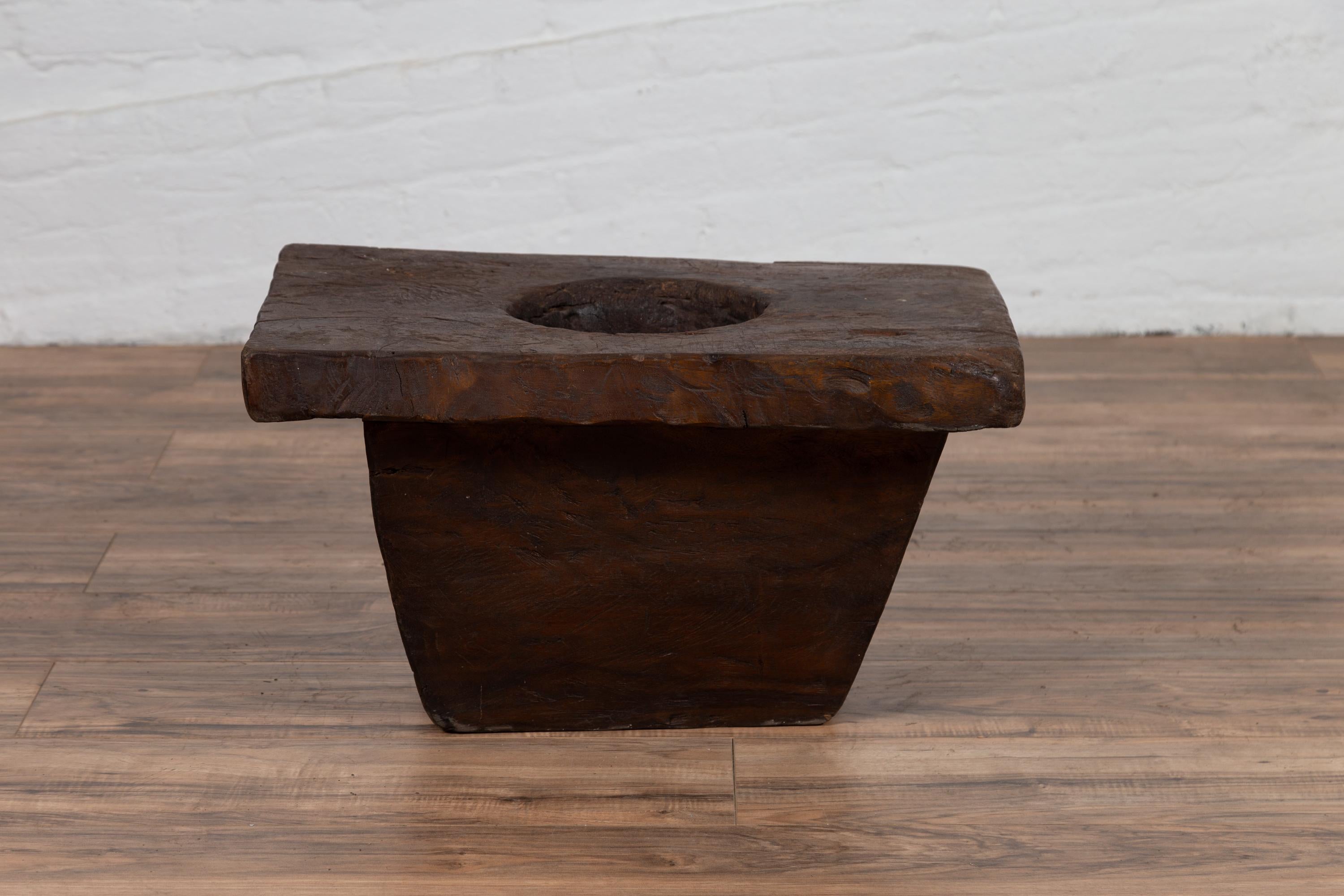 An antique Indonesian wooden planter of rustic appearance from the early 20th century. Born in Indonesia during the early years of the 20th century, this wooden planter charms our eyes with its simple appearance and weathered patina. Featuring a