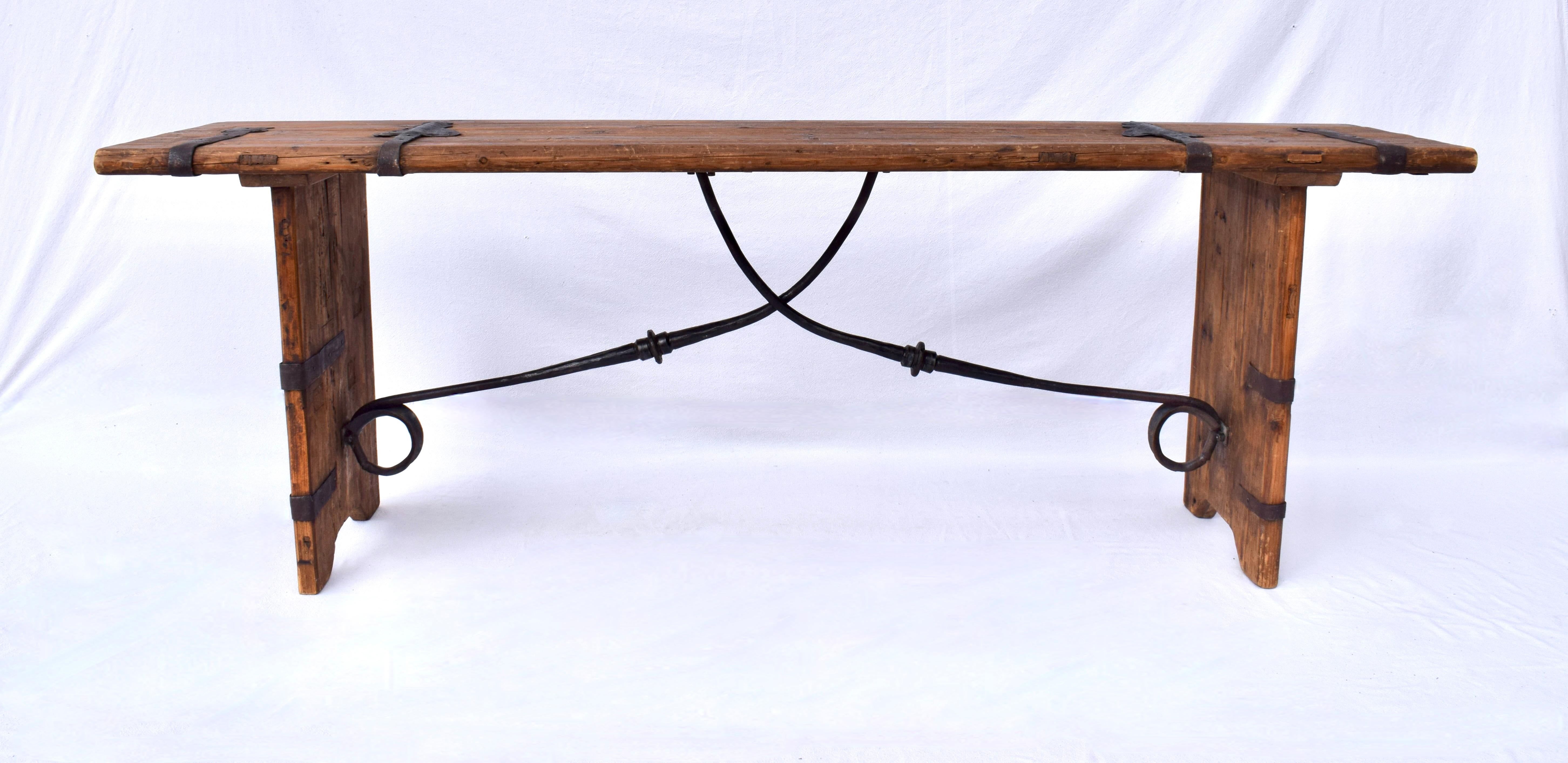 Impressive hand made console, serving or work table of reclaimed antique pine embellished with antique latches & forged iron stretcher. Boasting distinct Spanish monastery influences the table is suitable for a variety of uses.  Limited studio
