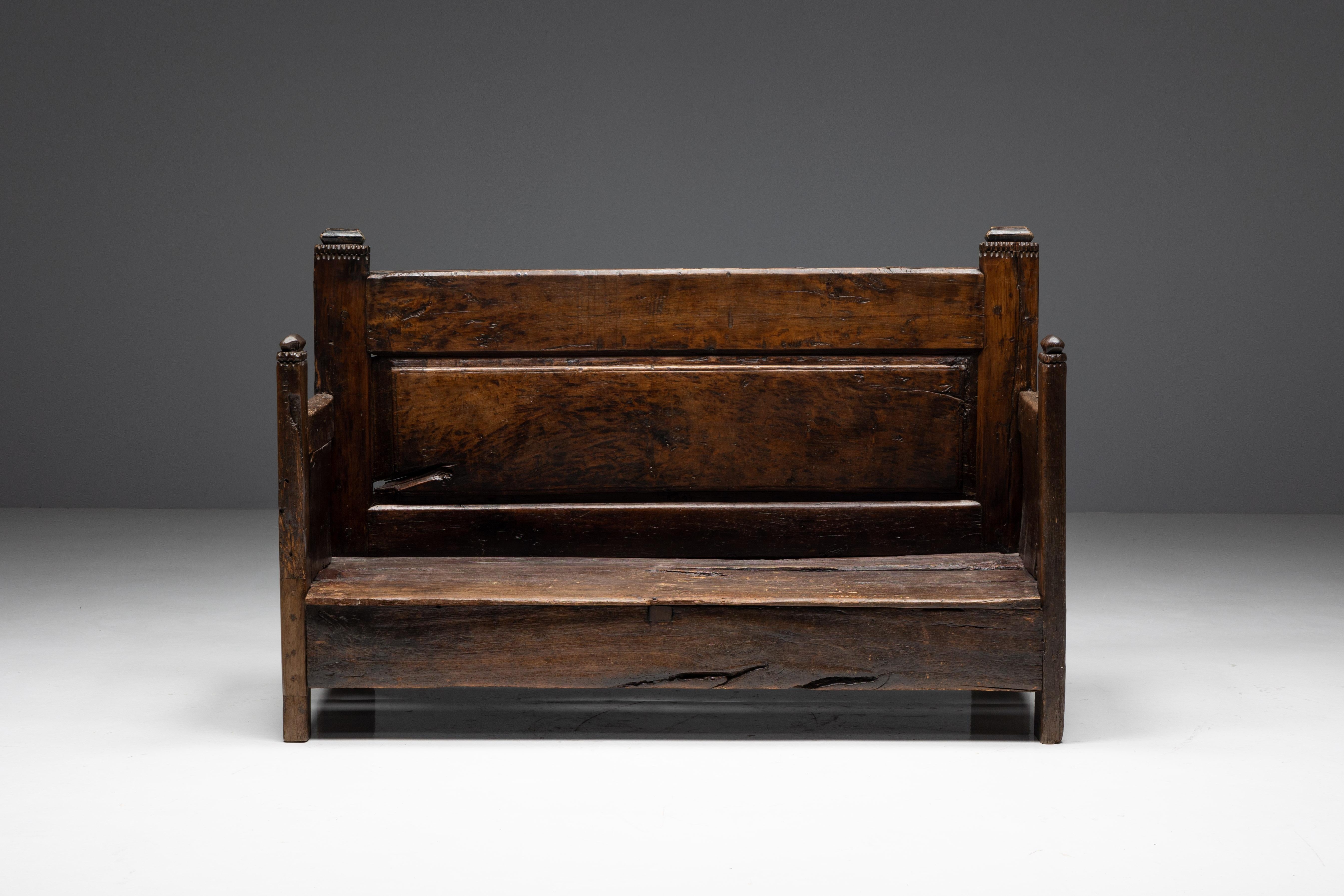 Rustic art populaire bench from 19th century France, with a charming primitive character. Constructed from sturdy wood, the bench boasts a rich patina that speaks to its age and history. Its simple design features a flat seat and four sturdy legs.