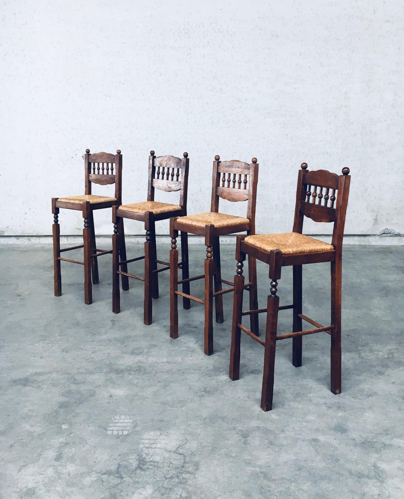 Vintage midcentury Era Rustic Design Bar Stool set of 4 in the style of Charles Dudouyt. Made in Romania, 1960s period. One chair is stamped (see picture). Solid oak hand carved frame with woven rush seat high bar stools. The ball shapes refer to