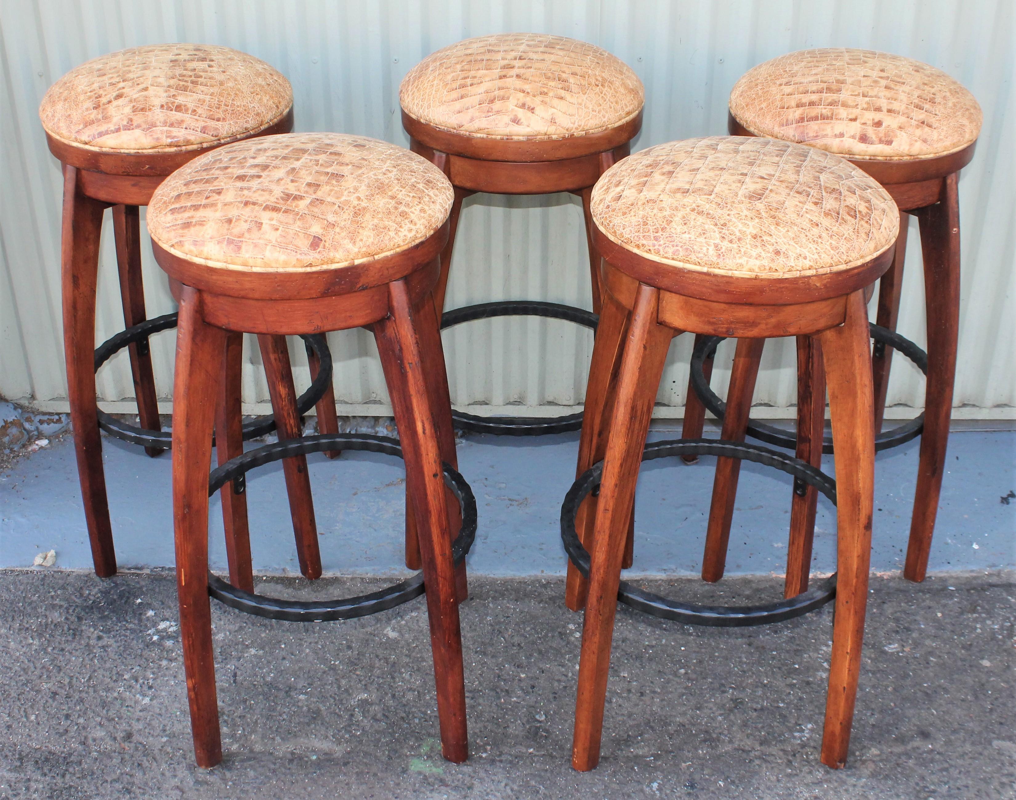 Wooden bar stools with iron foot rest and Italian alligator patterned and distressed leather swivel seats. Collection of five. We would sell three for 2695.