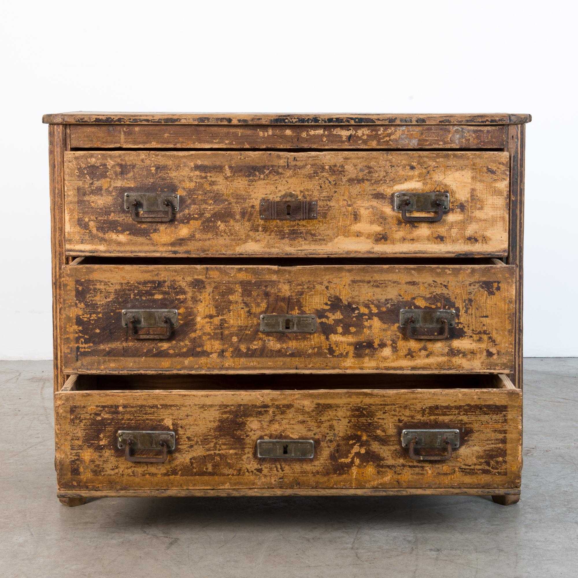 This chest of drawers is from late 19th century, Germany. A thick patina gives the pine surface a distinctive character. Original iron hardware features a geometric motif delicately incised with shallow relief, while bold rectangular plates emphasis