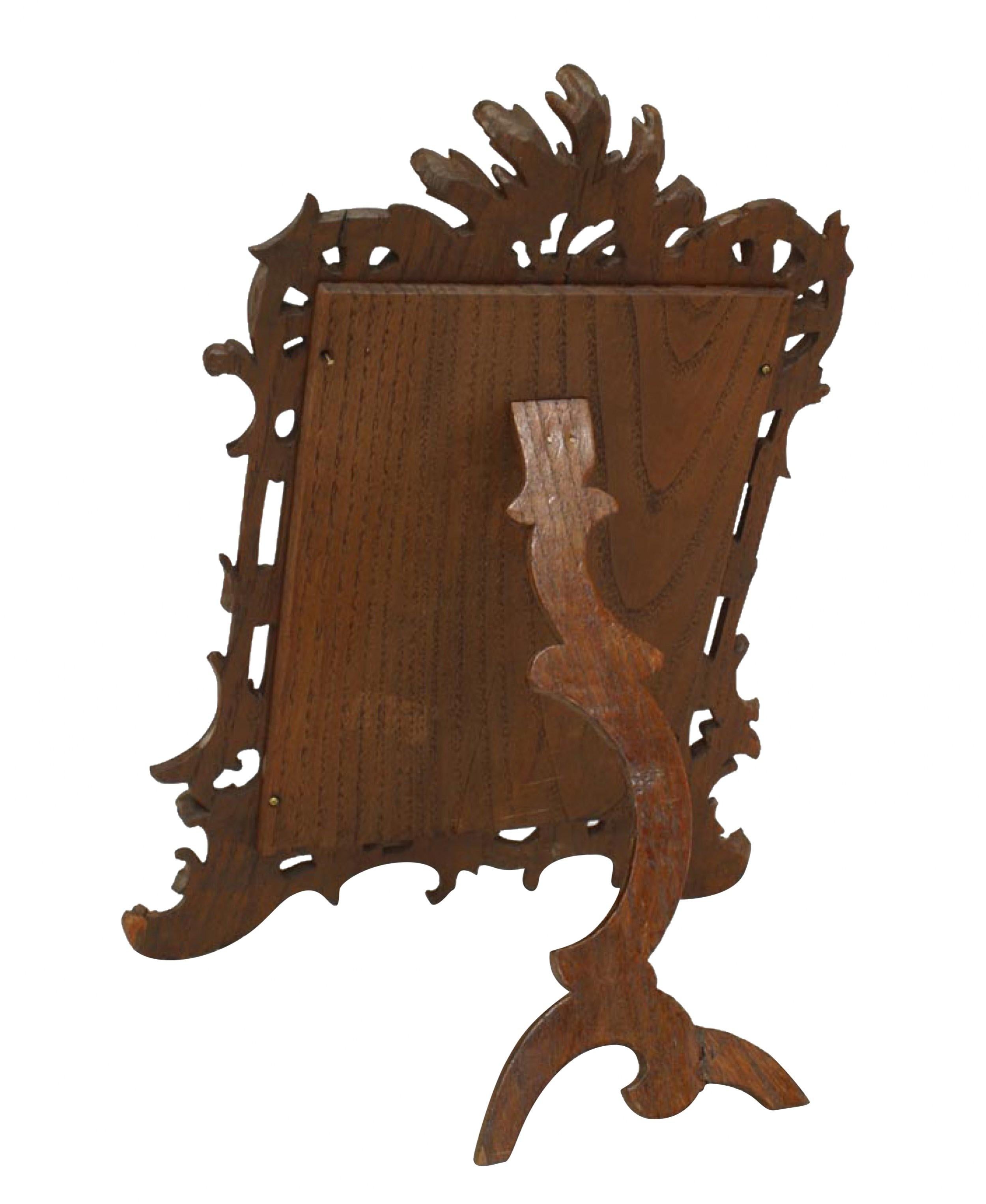 Rustic Black Forest-style stained oak carved easel picture frame with filigree and scroll design