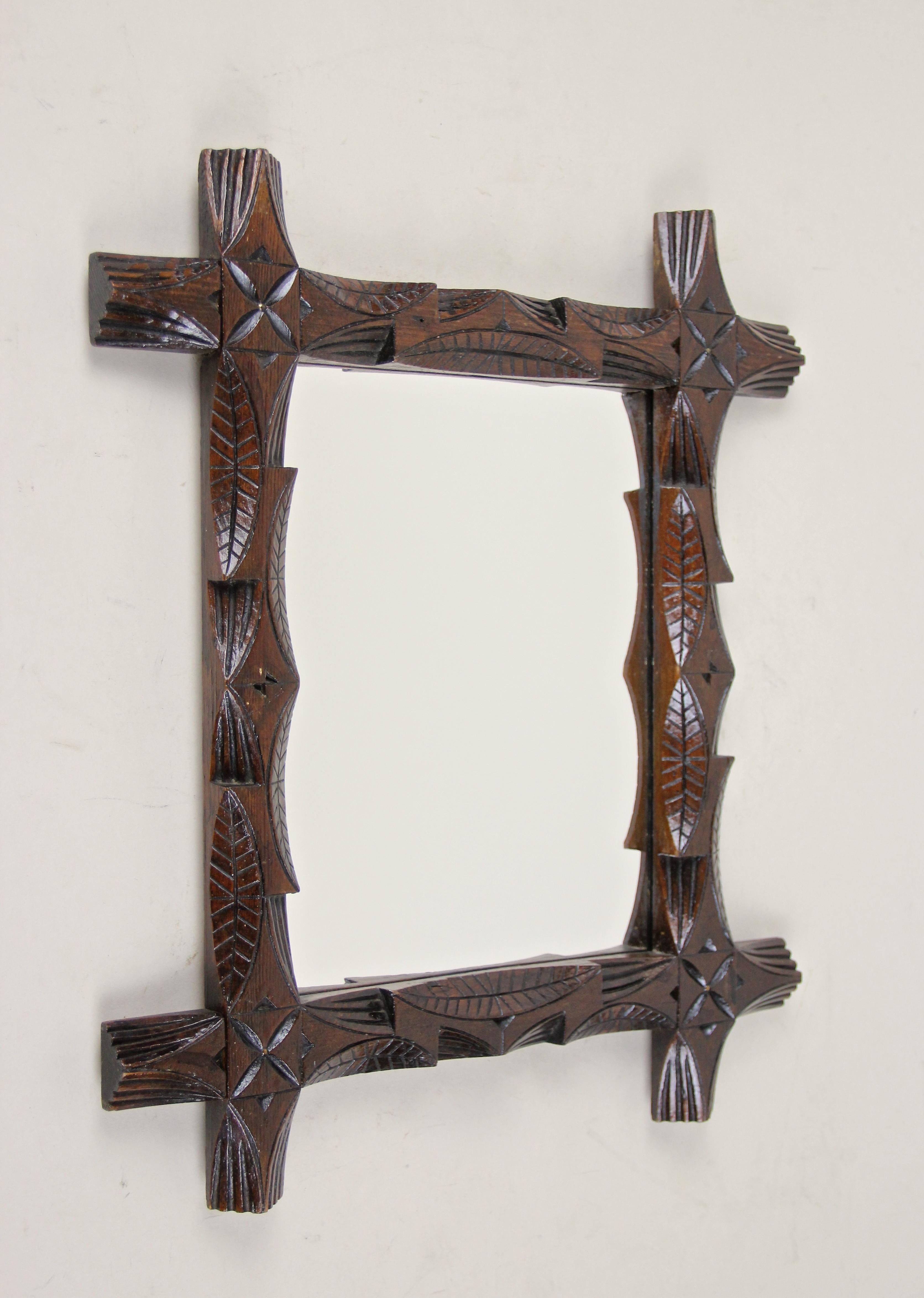 Lovely small Black Forest mirror from Austria, circa 1890. Artfully processed out of basswood, this frame shows unusual hand carved leaves designs and was combined with protruding corners. In line with the Black Forest theme the frame shows a very