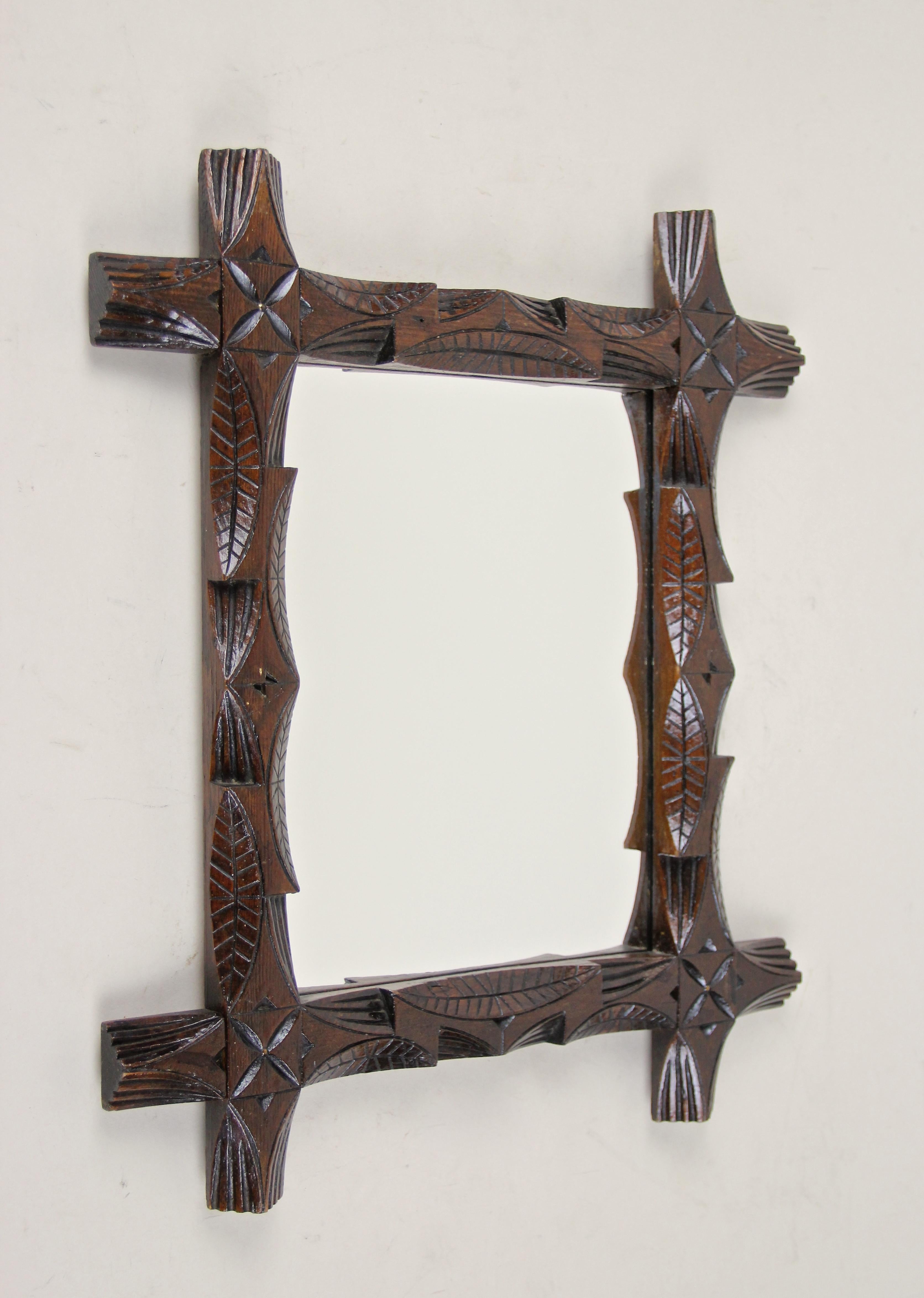 Delizioso specchio Black Forest di piccole dimensioni proveniente dall'Austria, circa 1890. Lavorata ad arte in legno di tiglio, questa cornice presenta insoliti disegni di foglie intagliate a mano ed è stata combinata con angoli sporgenti. In linea