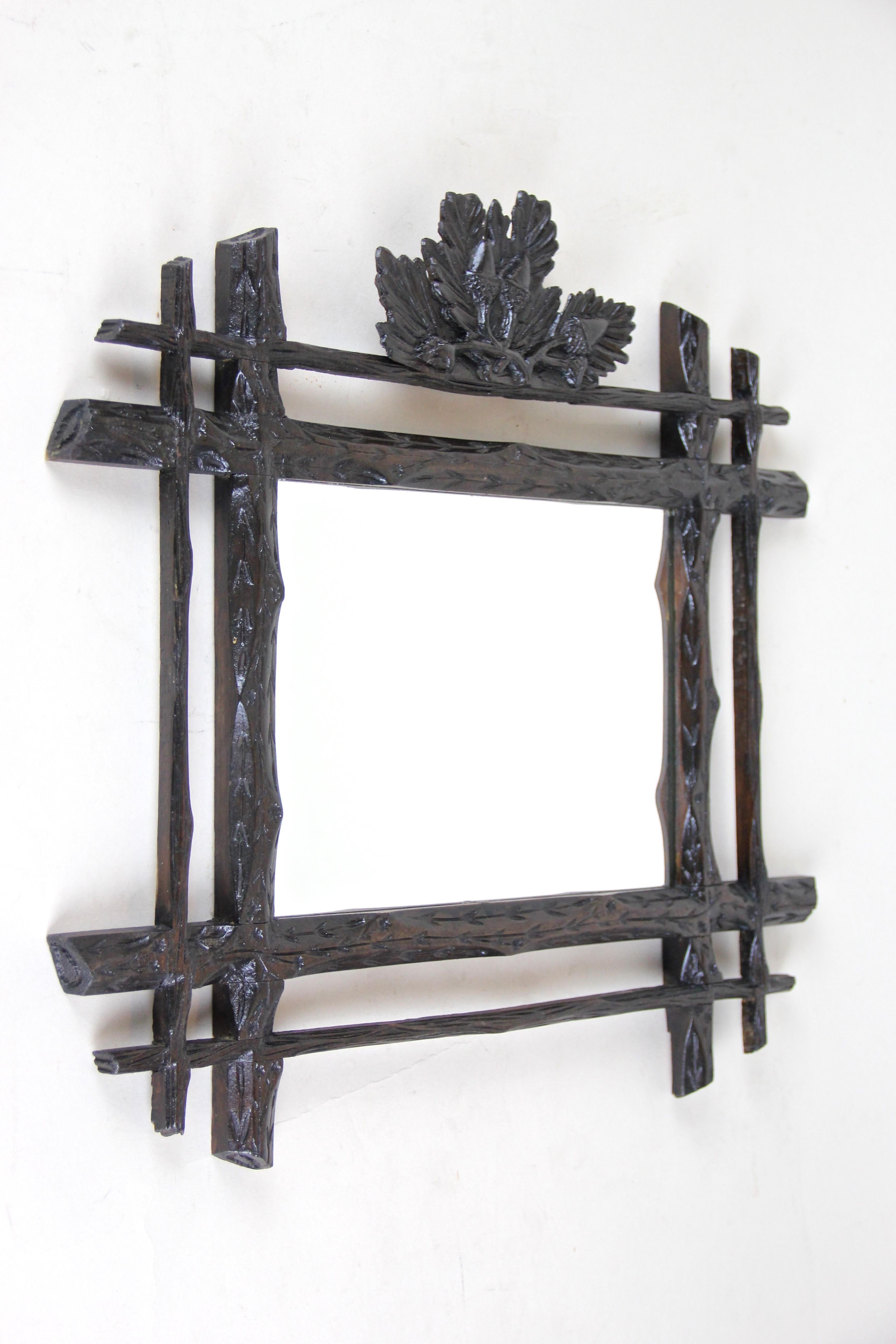 Small rustic Black Forest wall mirror from the late 19th century in Austria, circa 1880. A lovely wall mirror impressing with its roughly carved basswood double frame which shows delicate engraved flowers and blades of grass everywhere. A dark brown