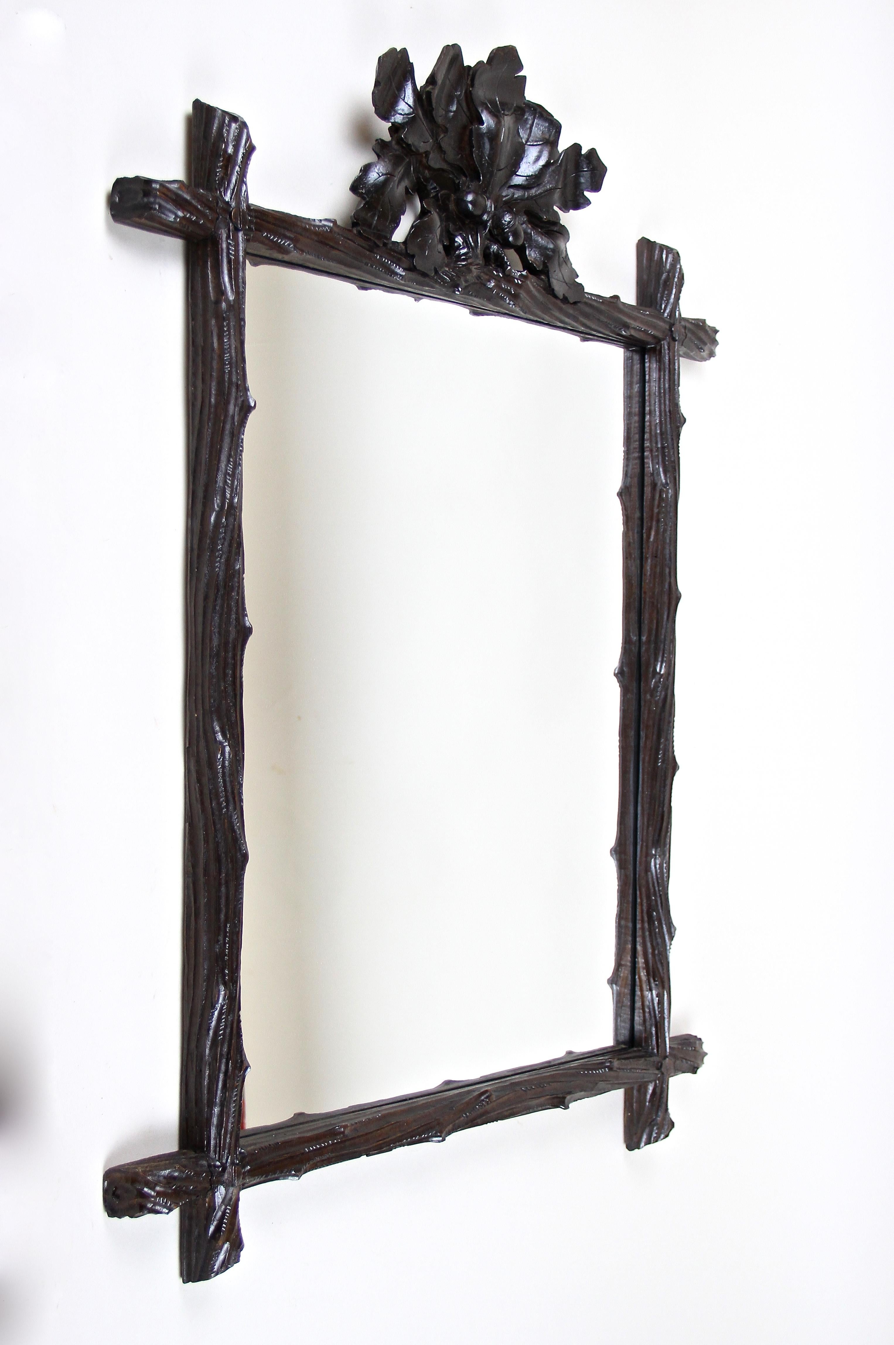 Exceptional black forest mirror from the late 19th century in Austria around 1870. This phenomenal, elaborately hand carved rustic wall mirror impresses with its simple but artfully designed 
