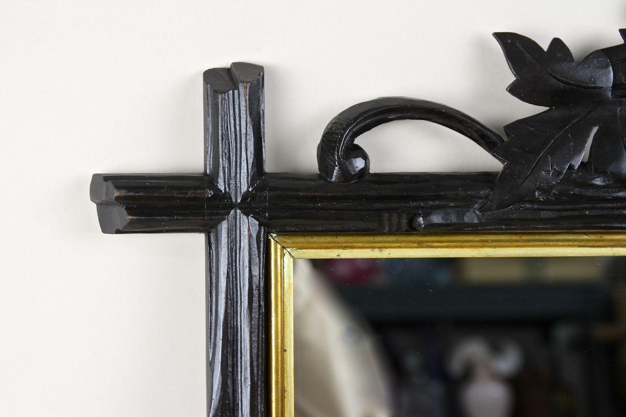 Eccezionale specchio da parete rustico della Black Forest, risalente al periodo intorno al 1870 in Germania. Scolpito a mano in legno di tiglio, questo fantastico specchio rurale colpisce per la sua cornice elaborata nello stile dei rami di un