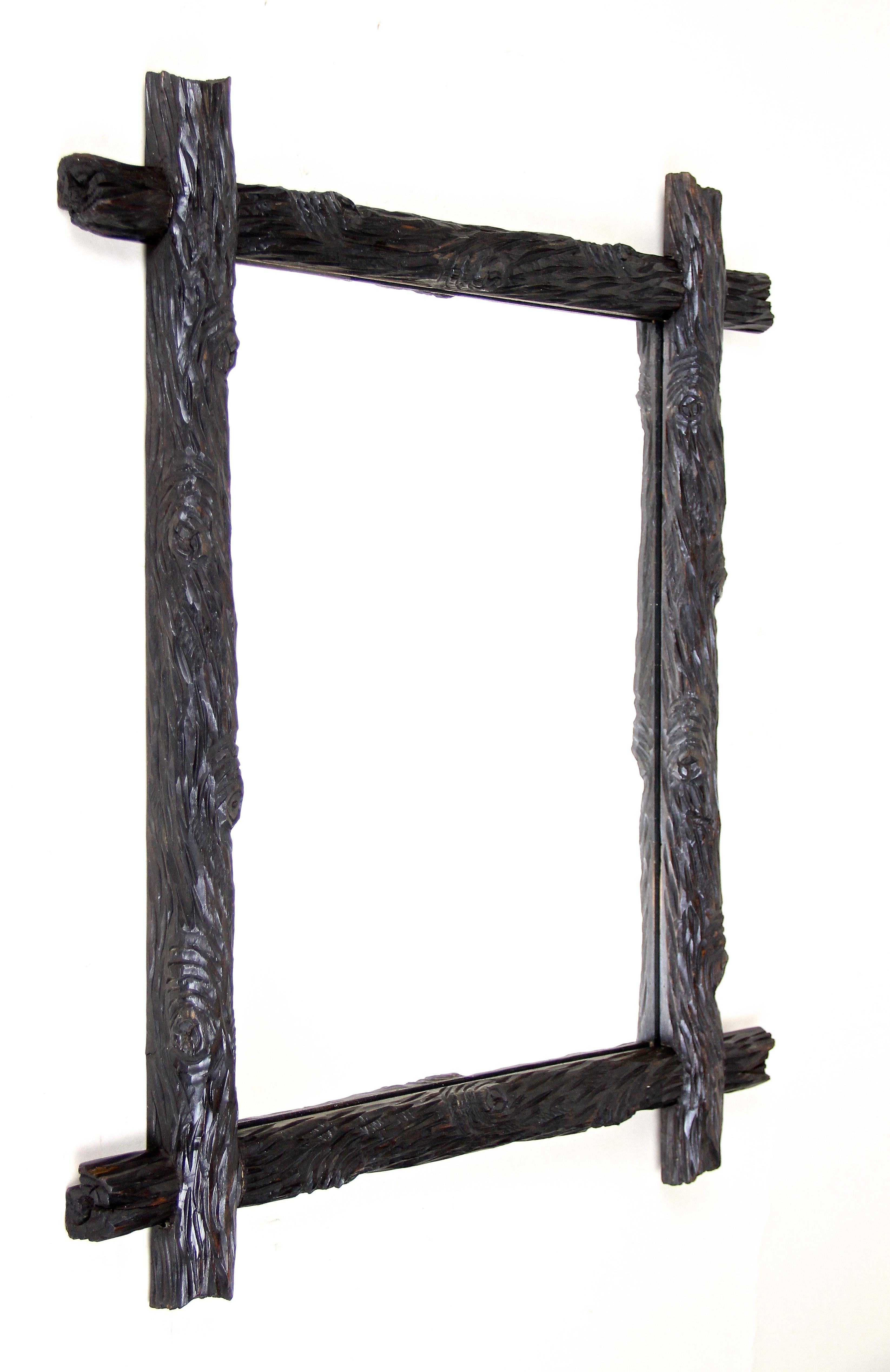 Out of Austria from circa 1870 comes this unique artfully hand carved Black Forest mirror, impressing with an unusual 