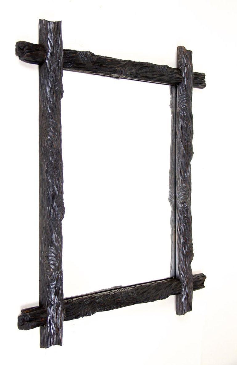 Out of Austria from circa 1880 comes this unique artfully hand carved Black Forest mirror, impressing with an unusual 