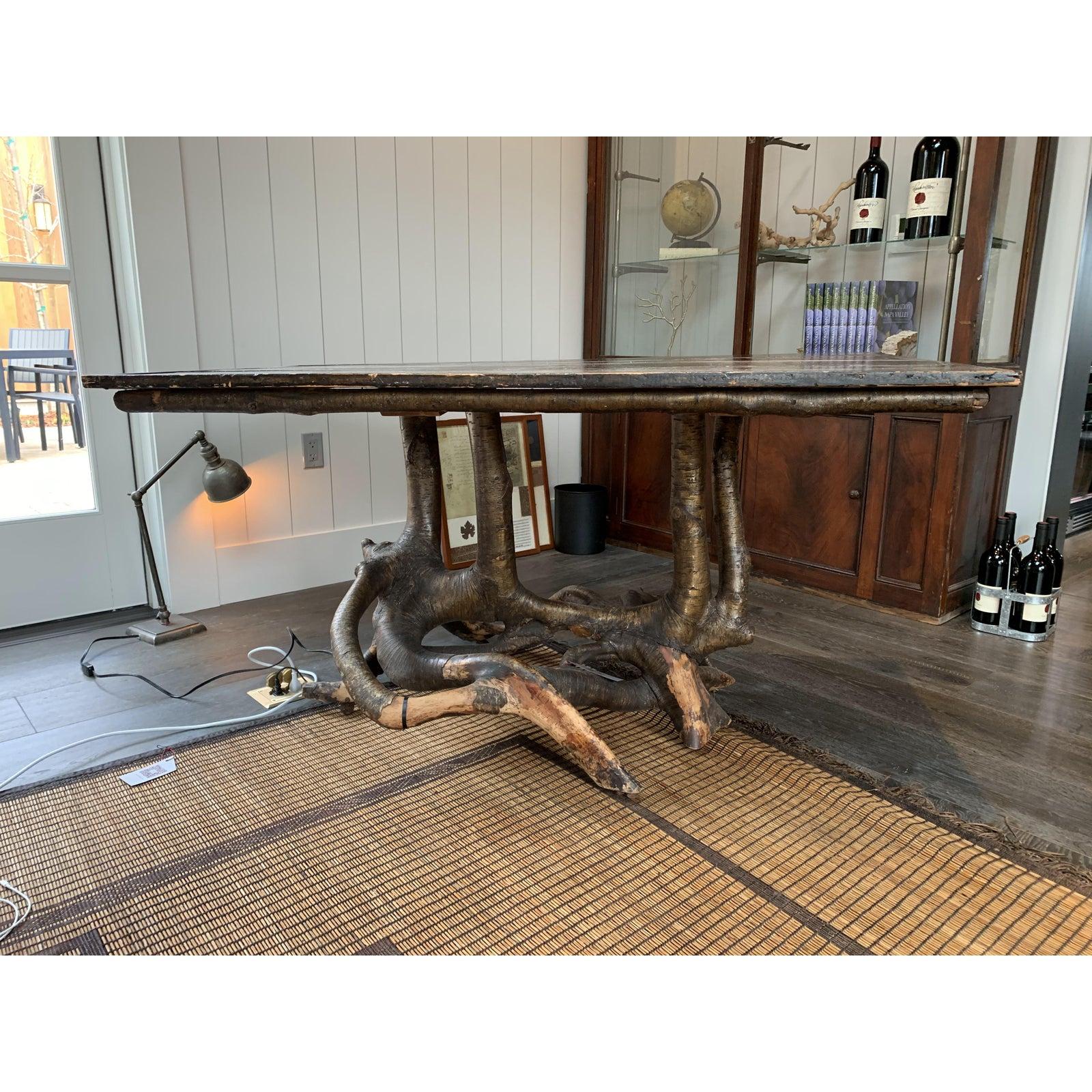 A beautiful rustic wood table featuring a tree branch as a pedestal base. This piece can be used as a console, desk or small dining table.