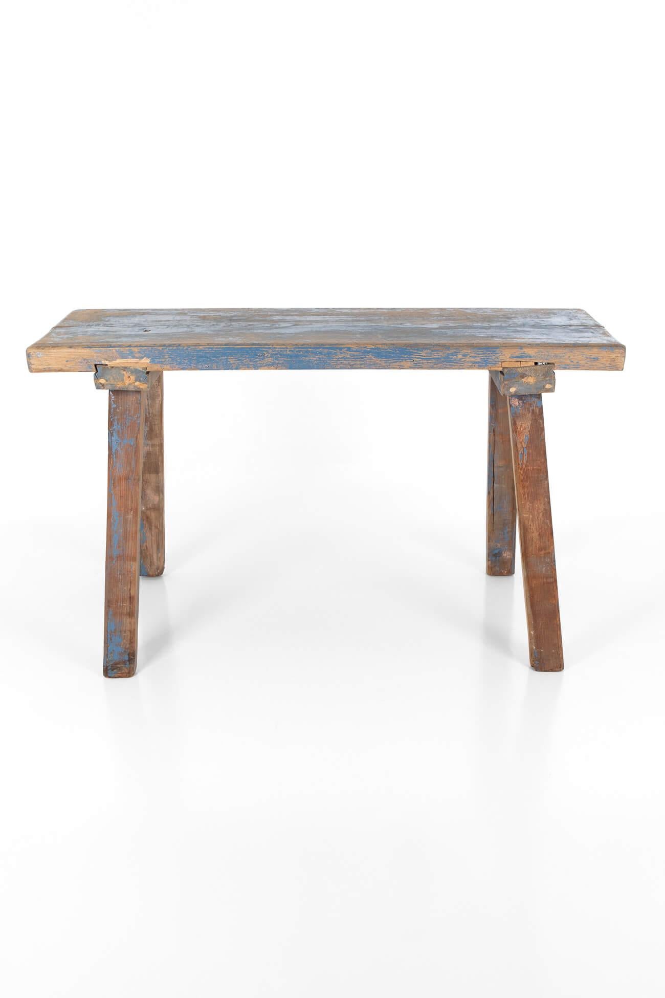 A proud rustic workshop table with a solid oak top raised on four sturdy pine block legs.

Traces of original blue paint to the top and legs with naive zinc supports to each end.

The table would make a wonderful hall console table or kitchen