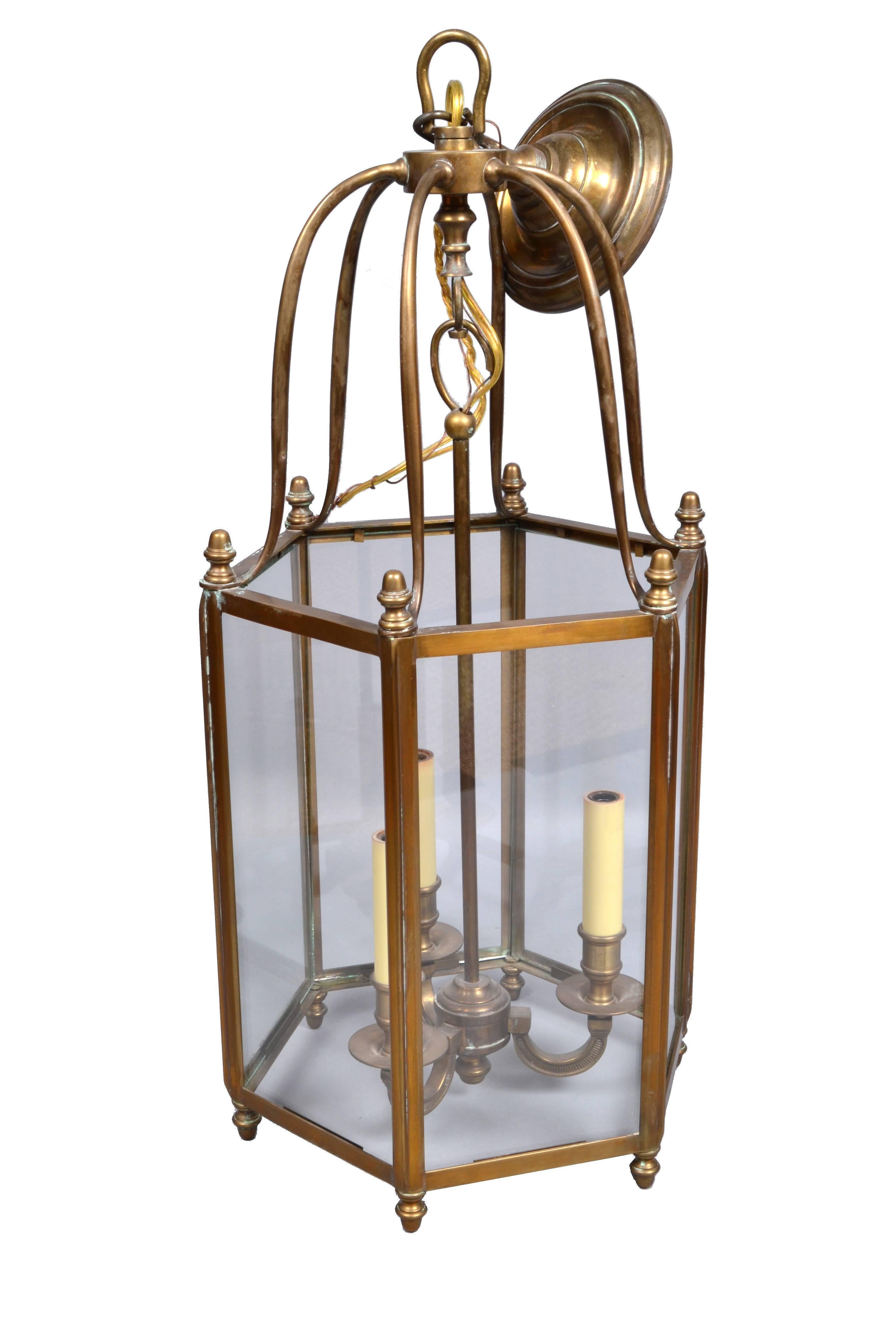 Lanterne de hall rustique en laiton et verre de style Hollywood Regency à trois lumières.
L'âme est constituée d'une tige en laiton, très détaillée.
Câblée pour les États-Unis, elle utilise trois ampoules de 40 watts.
