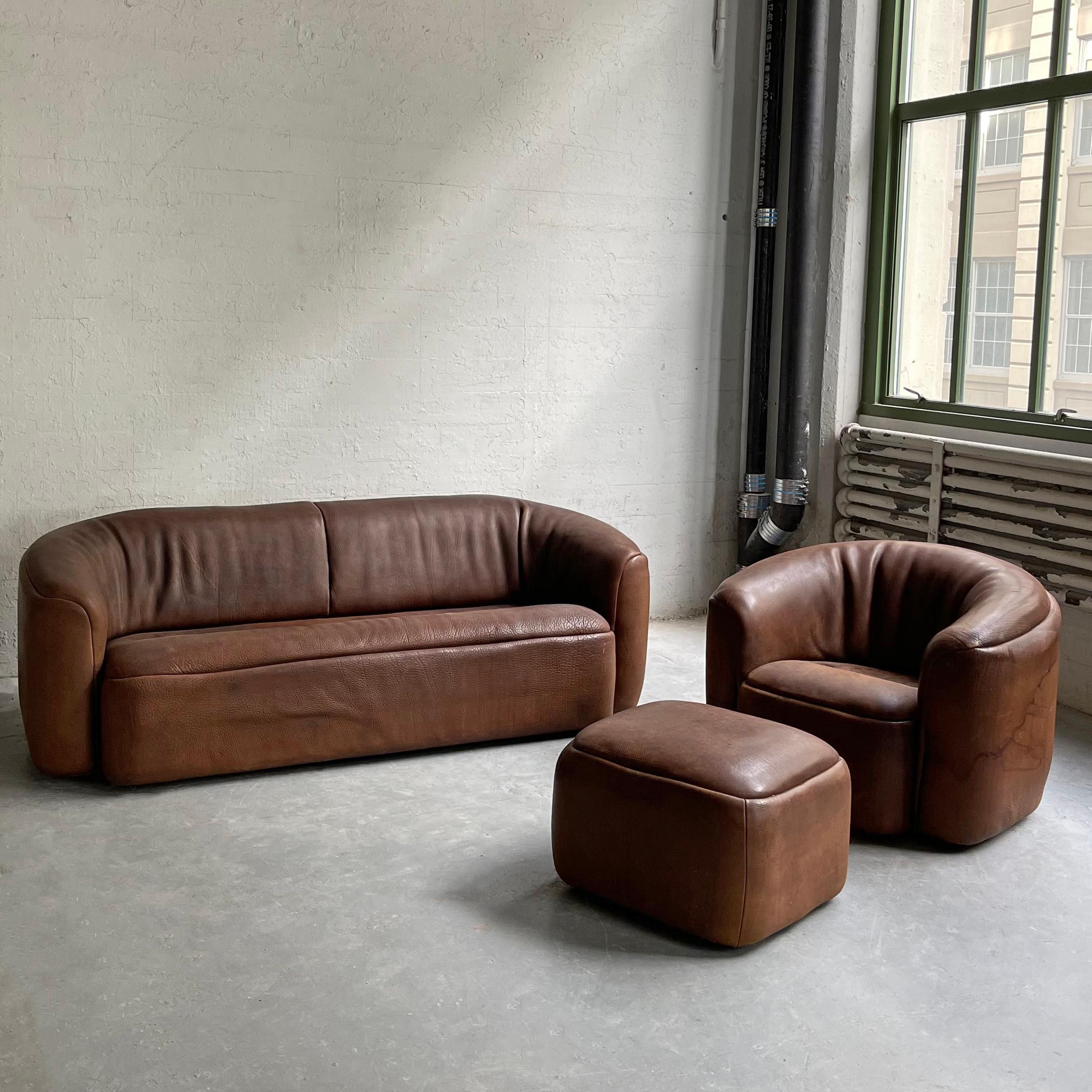 Handsome, rustic, 3 piece, buffalo hide sofa seating set includes a three seater sofa, club chair and ottoman. The durable, patinated buffalo hide features an earthy, brown tone with a deep textured grain that is soft and supple to the touch. The