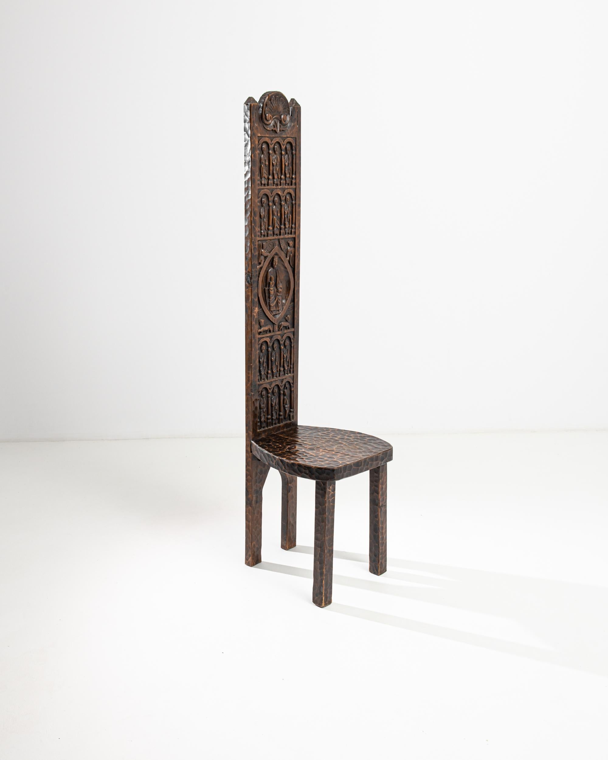 Though made in the 20th Century, this wooden chair echoes the design of the thrones of ancient French kings. The beautiful textural detail of the carved surface, heightened by the richness of the original patina, gives the effect of burnished metal