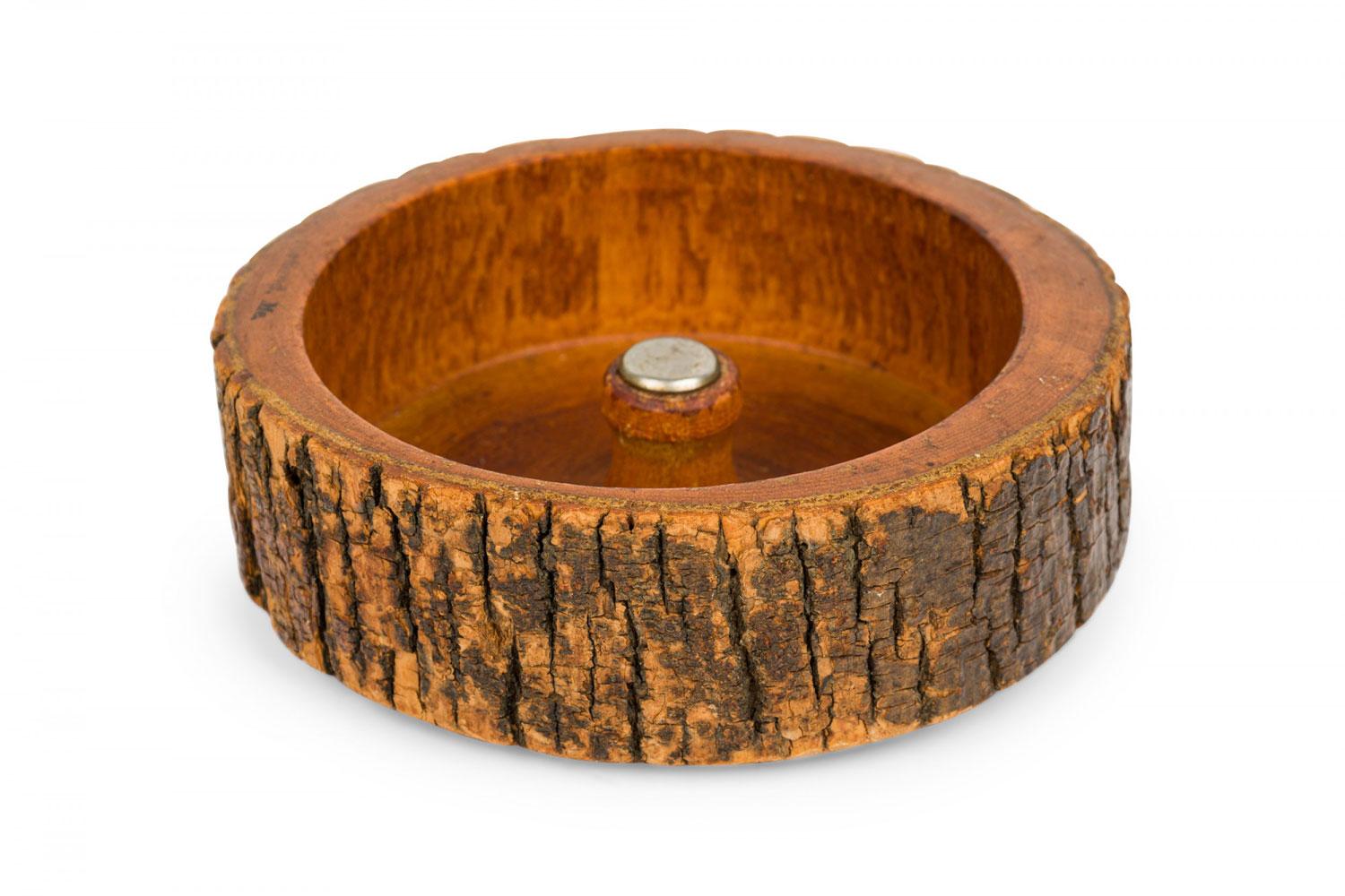 Rustic carved wooden nut cracker bowl with a bark exterior, wooden mallet, and various metal nut picks.