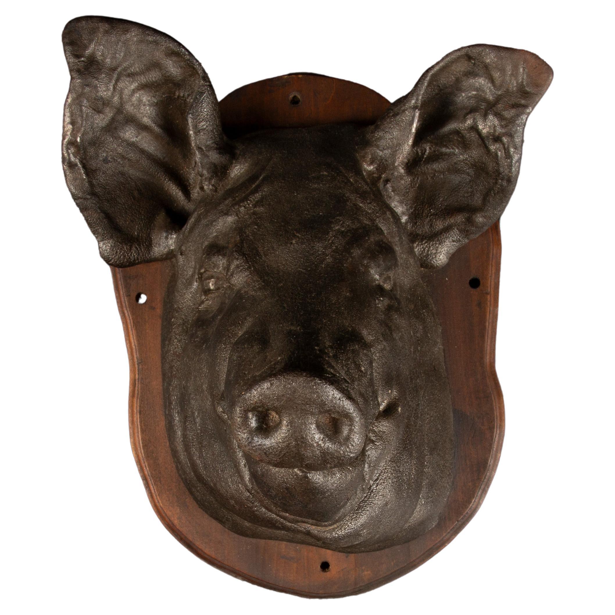 This Large Cast Iron Pig Head Trade Sign is a captivating piece of rustic charm and vintage appeal. Expertly crafted from durable cast iron, the sculpture features intricate detailing, capturing the lifelike features of a pig's head with remarkable