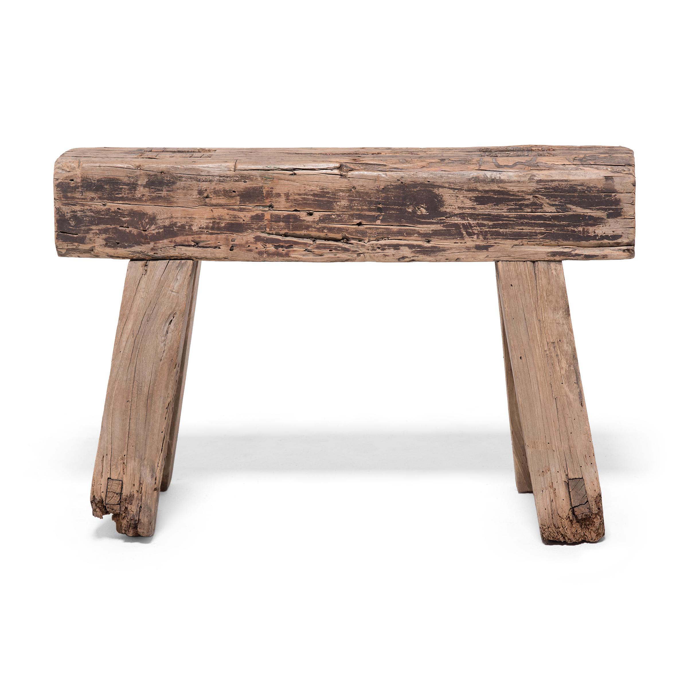 This short bench from Hebei province exemplifies rustic style with its simple design and wonderfully aged surface. Constructed of northern elm (yumu) using mortise-and-tenon joinery methods, the bench features splayed legs made of scrap wood and a